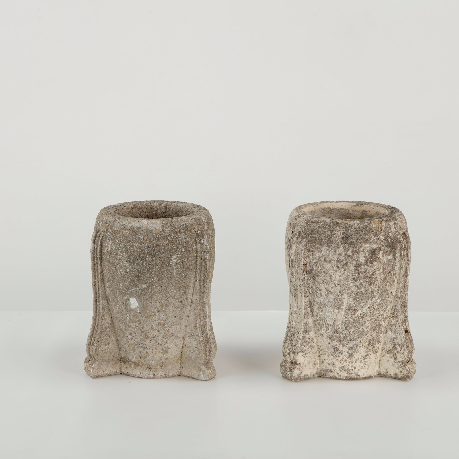 Pair of Tripod Stone Planters, 1950s: Pair of small stone planters raised on three integrated feet, featuring a compact sculptural form and deeply textured, timeworn surfaces. Height: 11 in. Diameter: 8 in. Opening Diameter: 6 in.