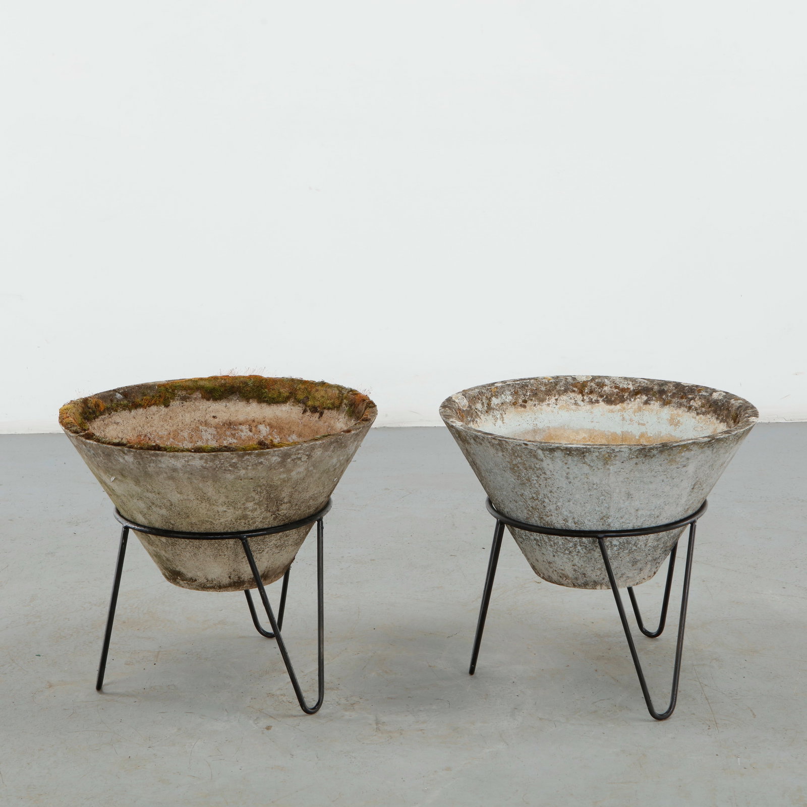 Willy Guhl, Pair of Conical Planters on Stands, 1960s: Iconic Willy Guhl silhouettes in compact form, these conical planters rest atop minimalistic metal stands, weathered yet timeless. Height: 19.5 in. Diameter: 22 in.