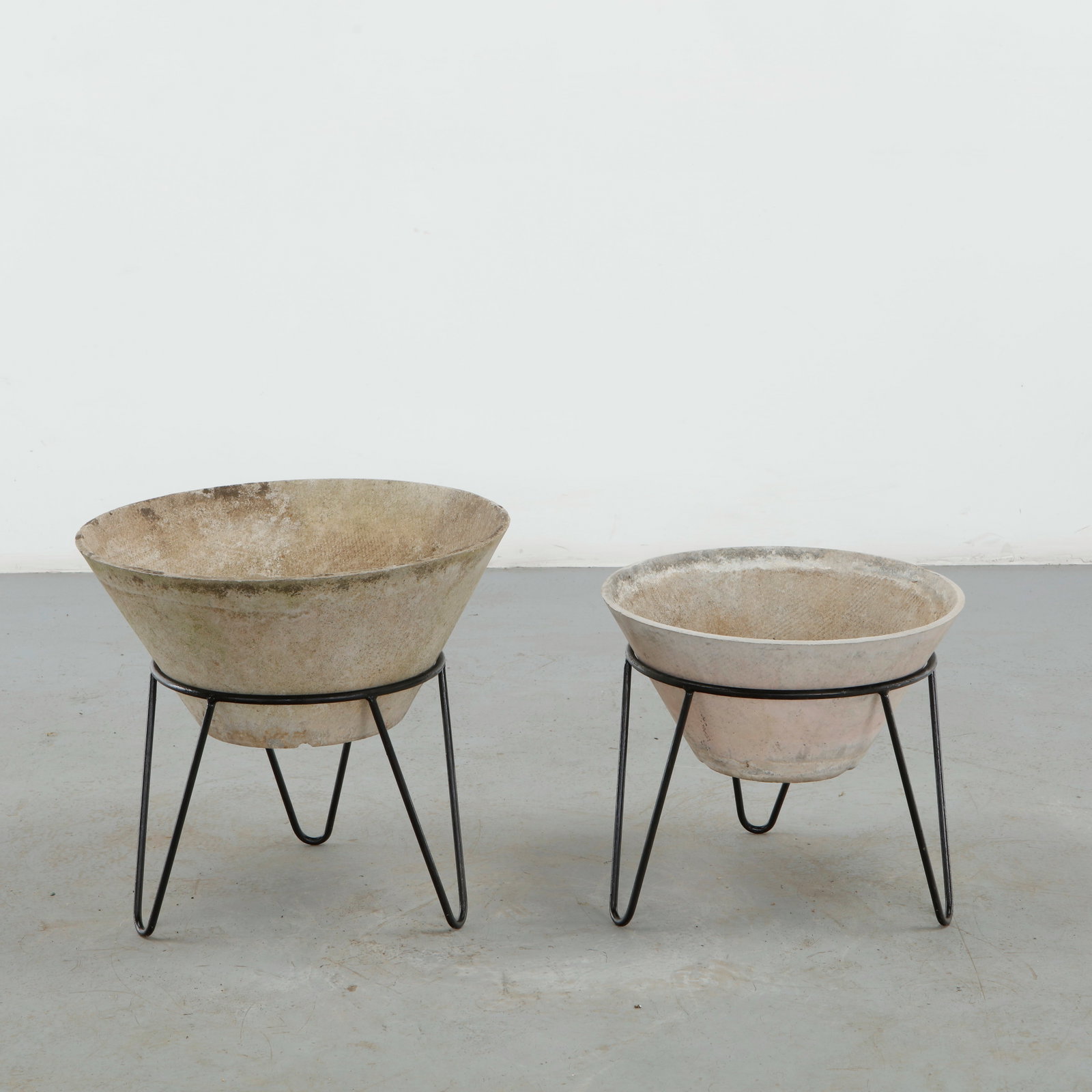 Willy Guhl, Pair of Conical Planters on Stands, 1960s: Iconic Willy Guhl silhouettes in compact form, these conical planters rest atop minimalistic metal stands, weathered yet timeless. 1: Height: 17 in. Diameter: 18 in. 2: Height: 19 in. Diameter: 21.5 i