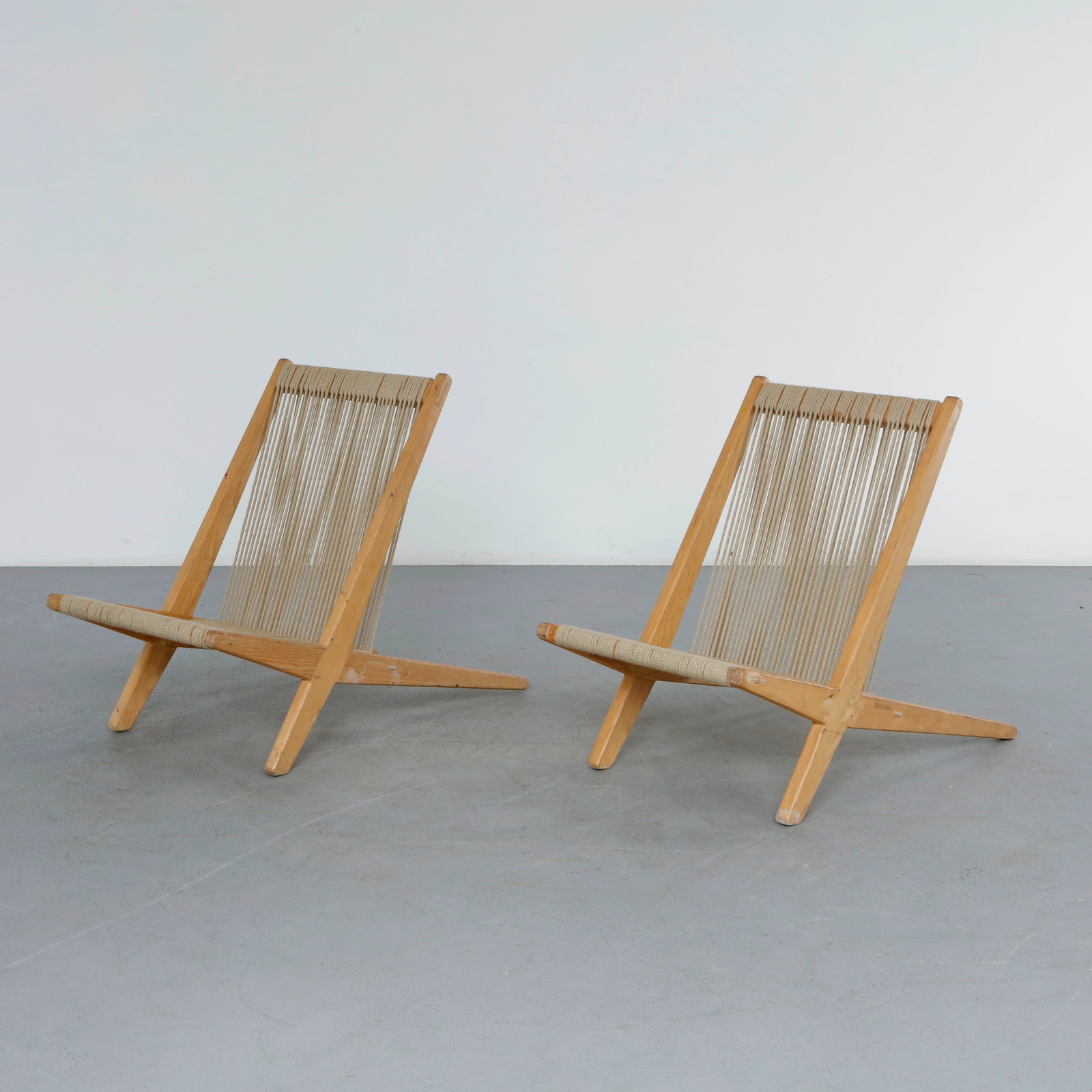 Pair of Danish Chairs in Pine and Papercord in the style of Poul Kjaerholm and Jorgen Hoj, 1960s: Pair of easy chairs crafted in solid pine with hand-woven papercord seats and backs. Their restrained lines, honest materials, and refined proportions reflect the enduring appeal of Scandinavian moder