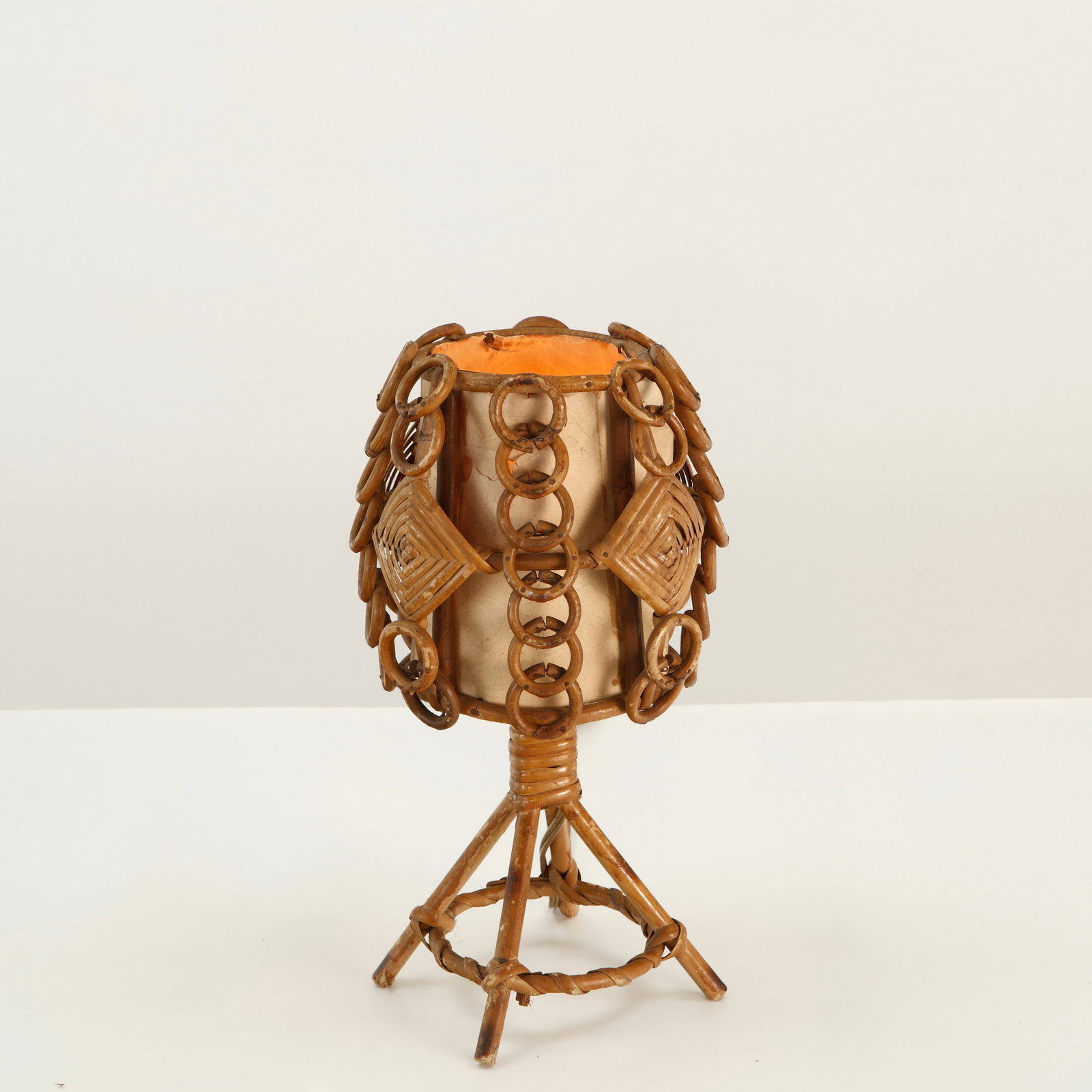 Louis Sognot, Rattan and Wicker Table Lamp with Ring Motif, 1960s: A distinctive table lamp by Louis Sognot, combining a woven rattan structure with a cylindrical shade and elaborate circular wicker ornament. The rhythmic construction lends the piece a strongly sculp