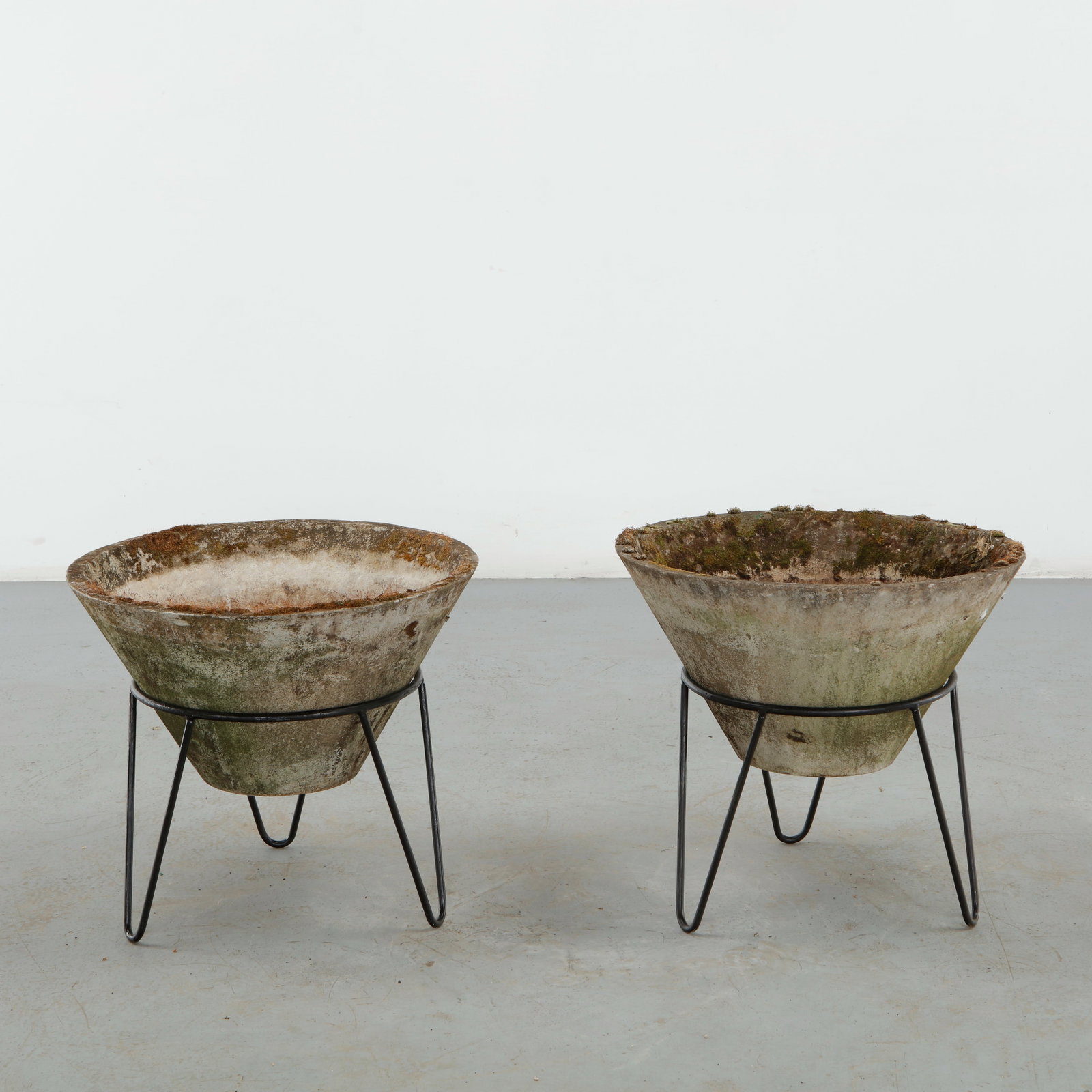 Willy Guhl, Pair of Conical Planters on Stands, 1960s: Iconic Willy Guhl silhouettes in compact form, these conical planters rest atop minimalistic metal stands, weathered yet timeless. Height: 19.5 in. Diameter: 22 in.