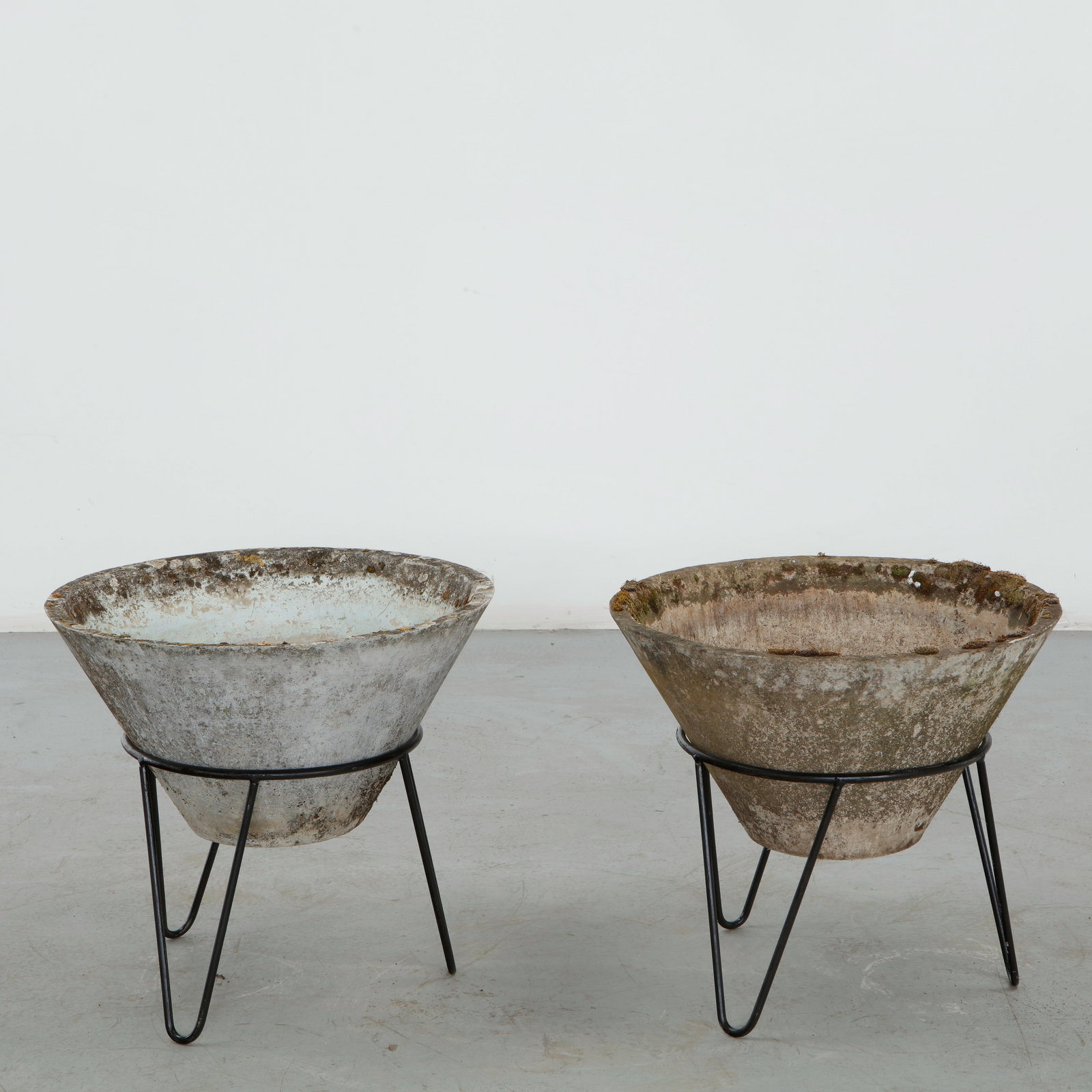 Willy Guhl, Pair of Conical Planters on Stands, 1960s: Iconic Willy Guhl silhouettes in compact form, these conical planters rest atop minimalistic metal stands, weathered yet timeless. Height: 19.5 in. Diameter: 22 in.
