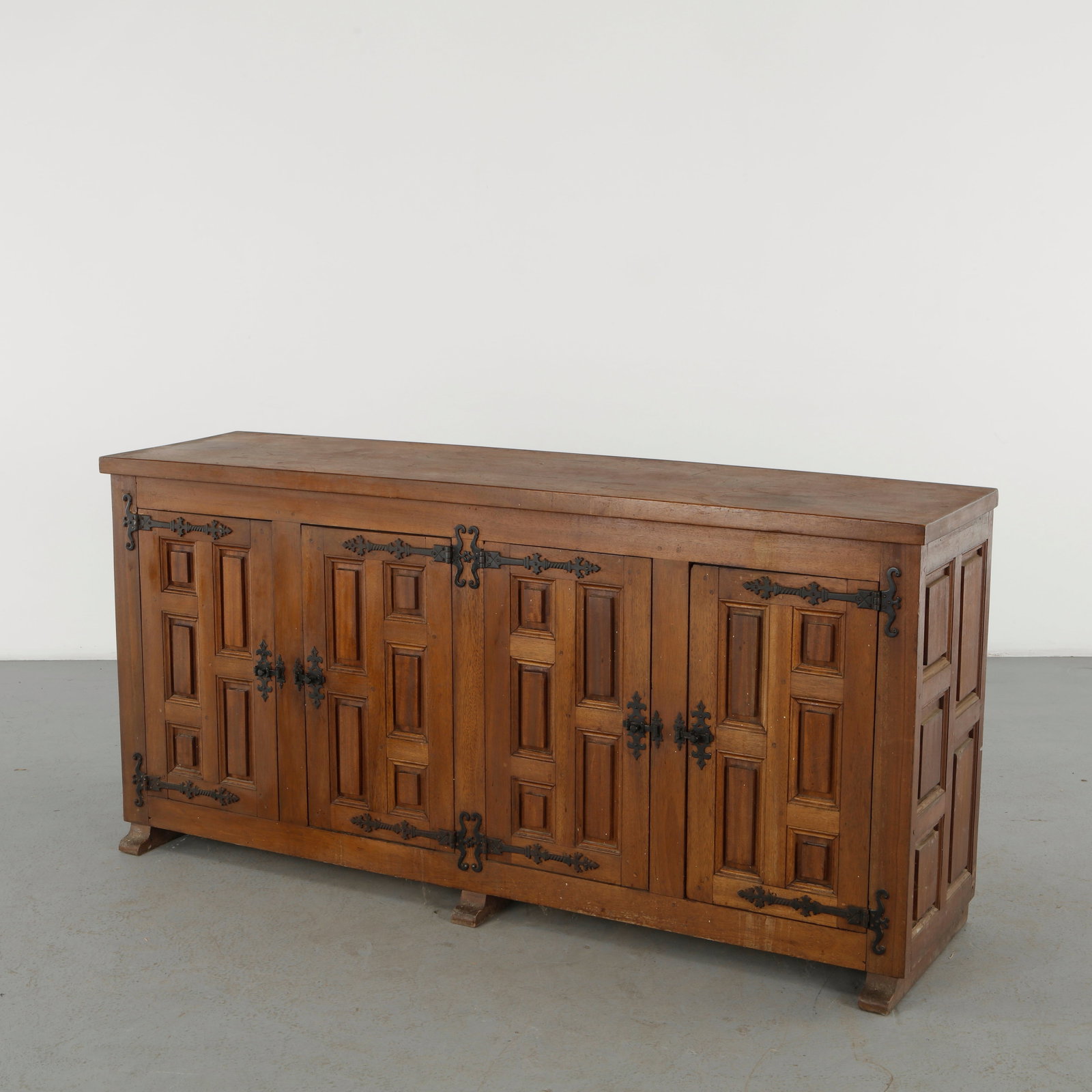 French Brutalist, Architectural Wood Sideboard, 1960s: A monumental wooden sideboard distinguished by deeply recessed geometric panels, wrought iron hardware and a heavily articulated faÃ§ade. Its austere construction and emphatic surface trea