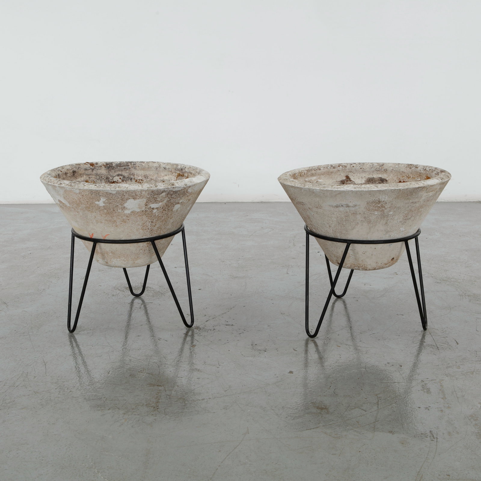 Willy Guhl, Pair of Conical Planters on Stands, 1960s: Iconic Willy Guhl silhouettes in compact form, these conical planters rest atop minimalistic metal stands, weathered yet timeless. Height: 19.5 in. Diameter: 22 in.