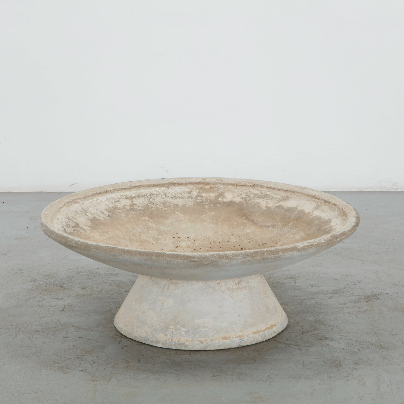 Willy Guhl, Large Bowl Planter on Concrete Stand, 1960s: A generously scaled bowl planter in fiber cement, raised on an integral tapering pedestal base. Uniform cream patina with light surface soiling to the interior. Height: 15 in. Diameter: 39 in.