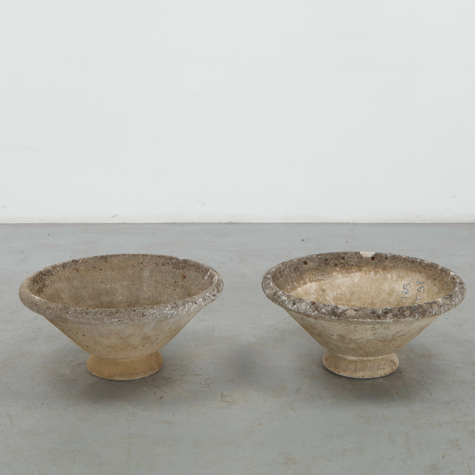 Grandon Fres, Pair of Round Planter on Stand, 1960s: A rare pair of sculptural concrete planters by Grandon Fres, each formed as a broad, shallow bowl raised on a compact pedestal foot. The weathered surfaces display a richly developed patina of mineral