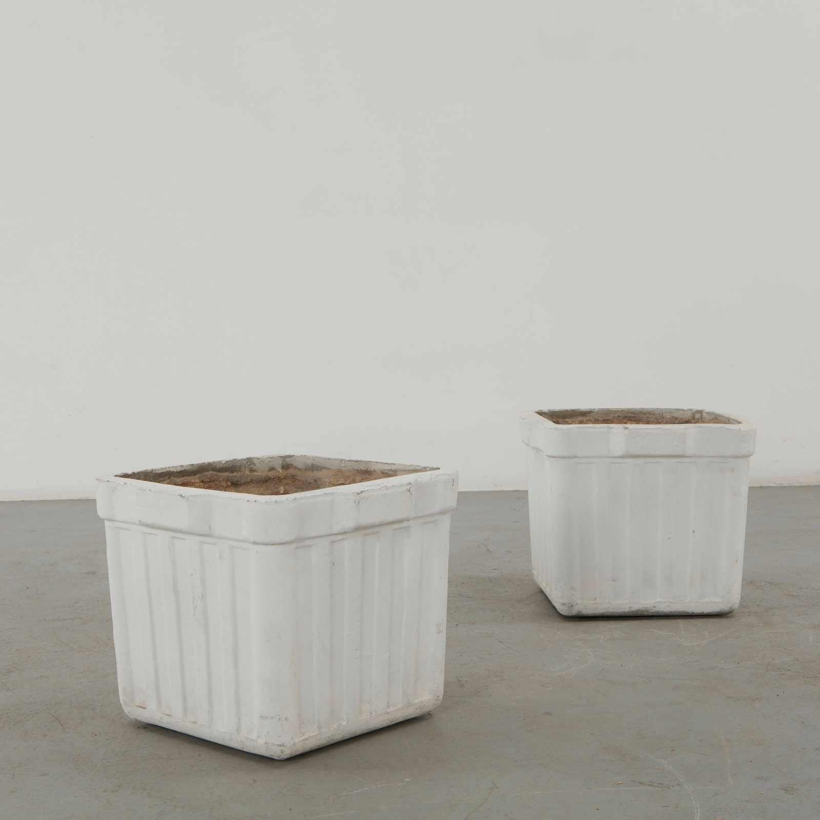 Willy Guhl, Pair of Square Fluted Planters, 1960s: Willy Guhl pair of square concrete planters distinguished by vertically fluted walls and substantial raised rims. Their restrained geometry and weathered white finish exemplify Guhl enduring approach 
