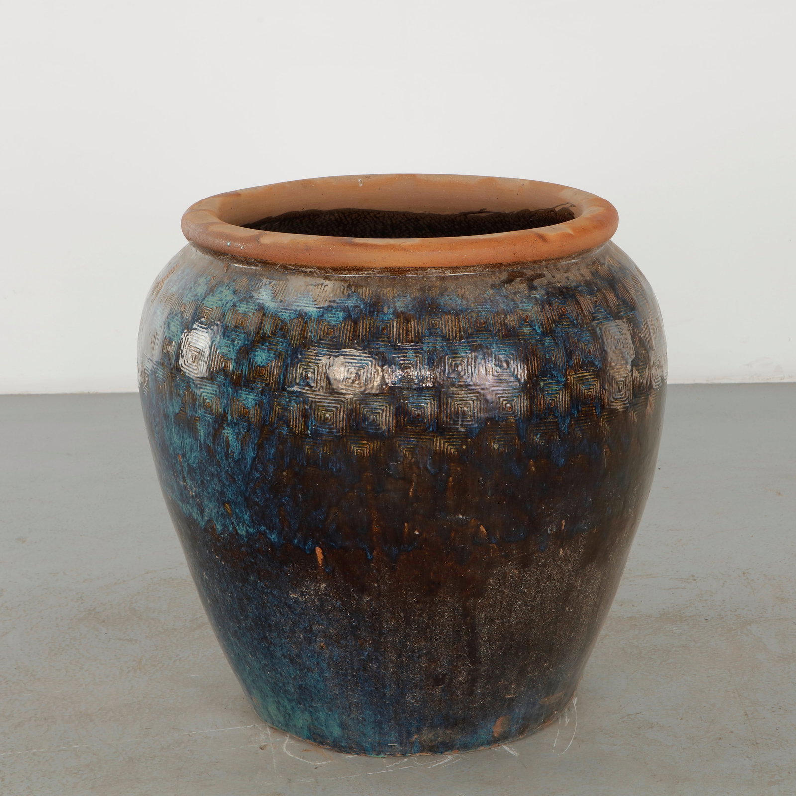 Large Glazed Ceramic Planter with Turquoise Geometric Band, 1960s: Large rounded ceramic planter distinguished by a richly variegated dark glaze in blue, brown and green tones, enhanced by a repeated incised geometric motif. The substantial vessel combines an