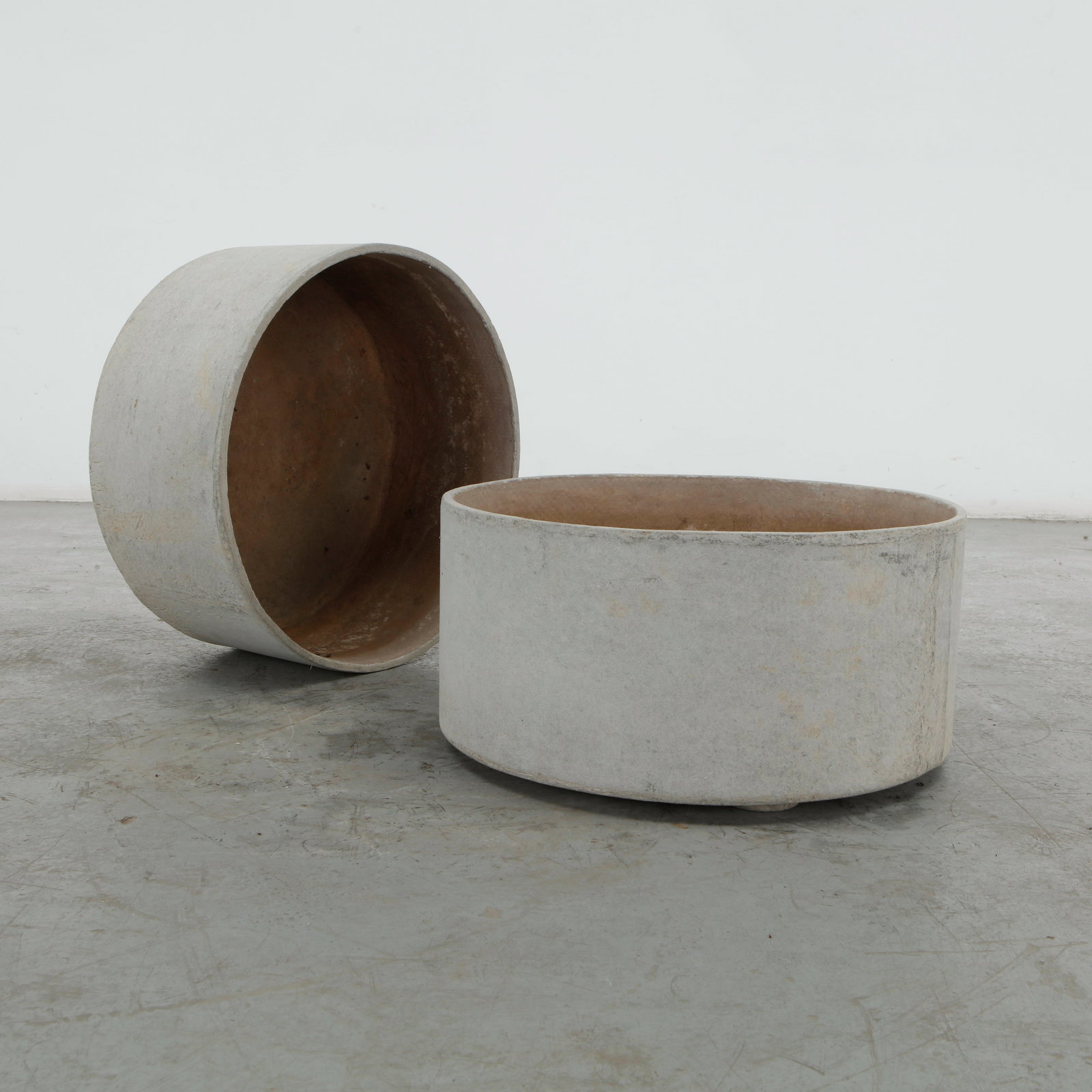 Willy Guhl, Pair of Round Planters, 1970s: Pair of round cast concrete planters by Willy Guhl, distinguished by their generous proportions and softly rounded forms. The restrained construction highlights Guhl affinity for functional
