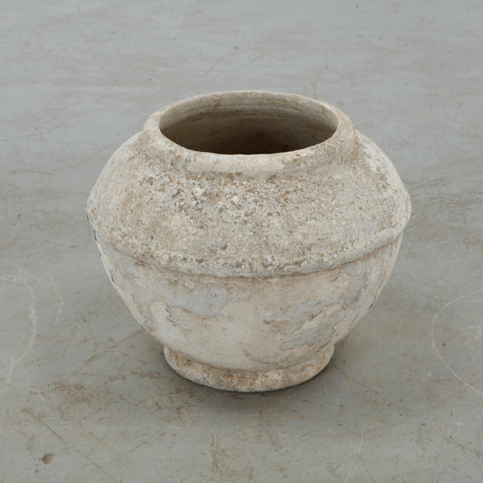 Willy Guhl, Urn Planter: Featuring a rounded, almost spherical body raised on a compact integral foot, this concrete planter reflects Guhl exploration of softened geometric volumes. Its naturally weathered surface reveals the