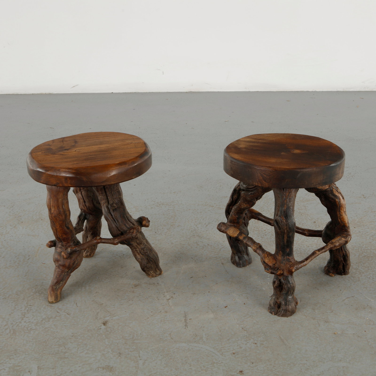 Pair of Vine Stools, 1960s: A charming pair of sculptural Vine stools, executed in solid wood with organically articulated bases inspired by intertwined branches. The naturalistic construction and richly aged surfaces create a s