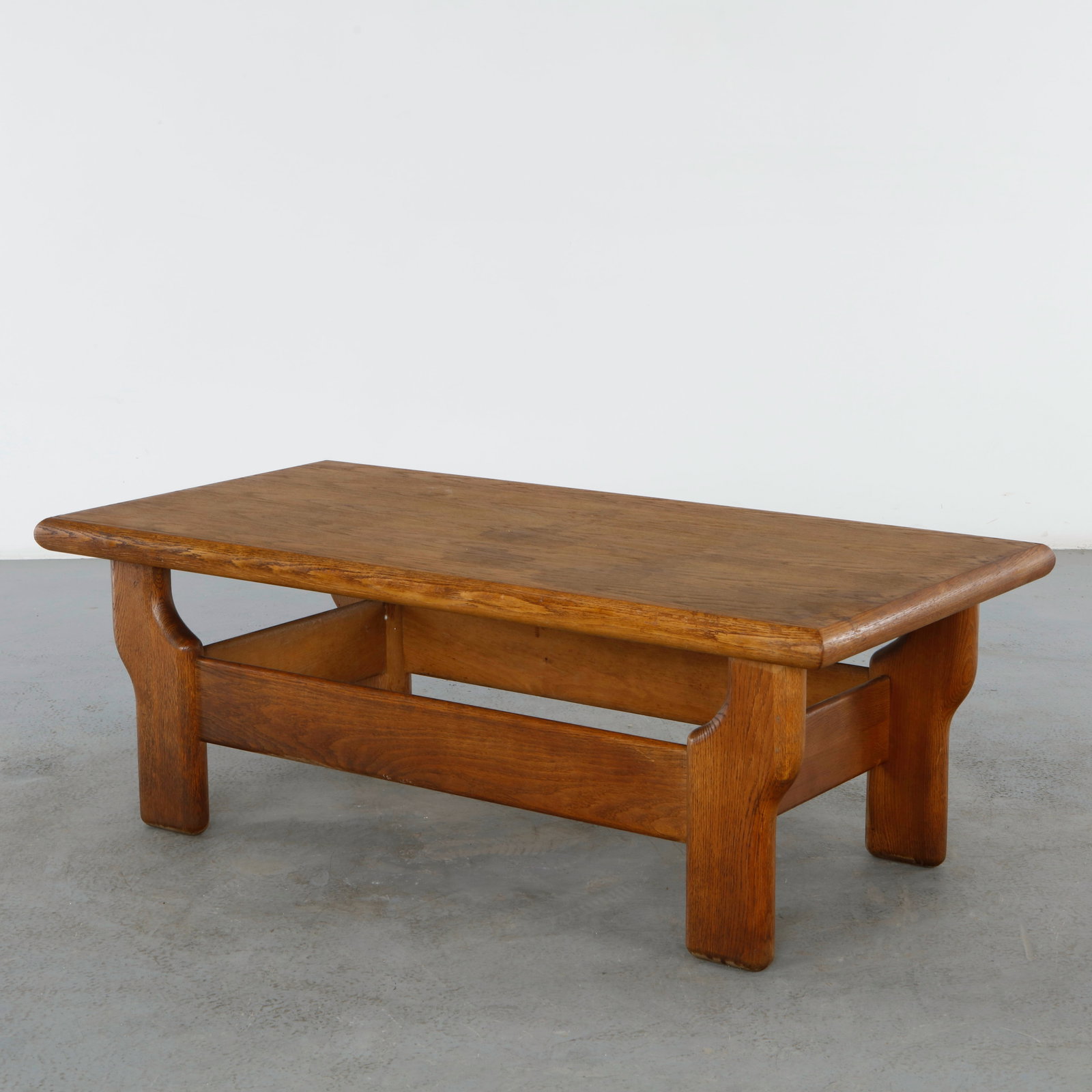 Maison Regain, Wood Coffee Table, 1960s: Solid oak coffee table by Maison Regain, showcasing the workshop signature commitment to natural materials and robust craftsmanship. The simple architectural form highlights the beauty of the wood gra