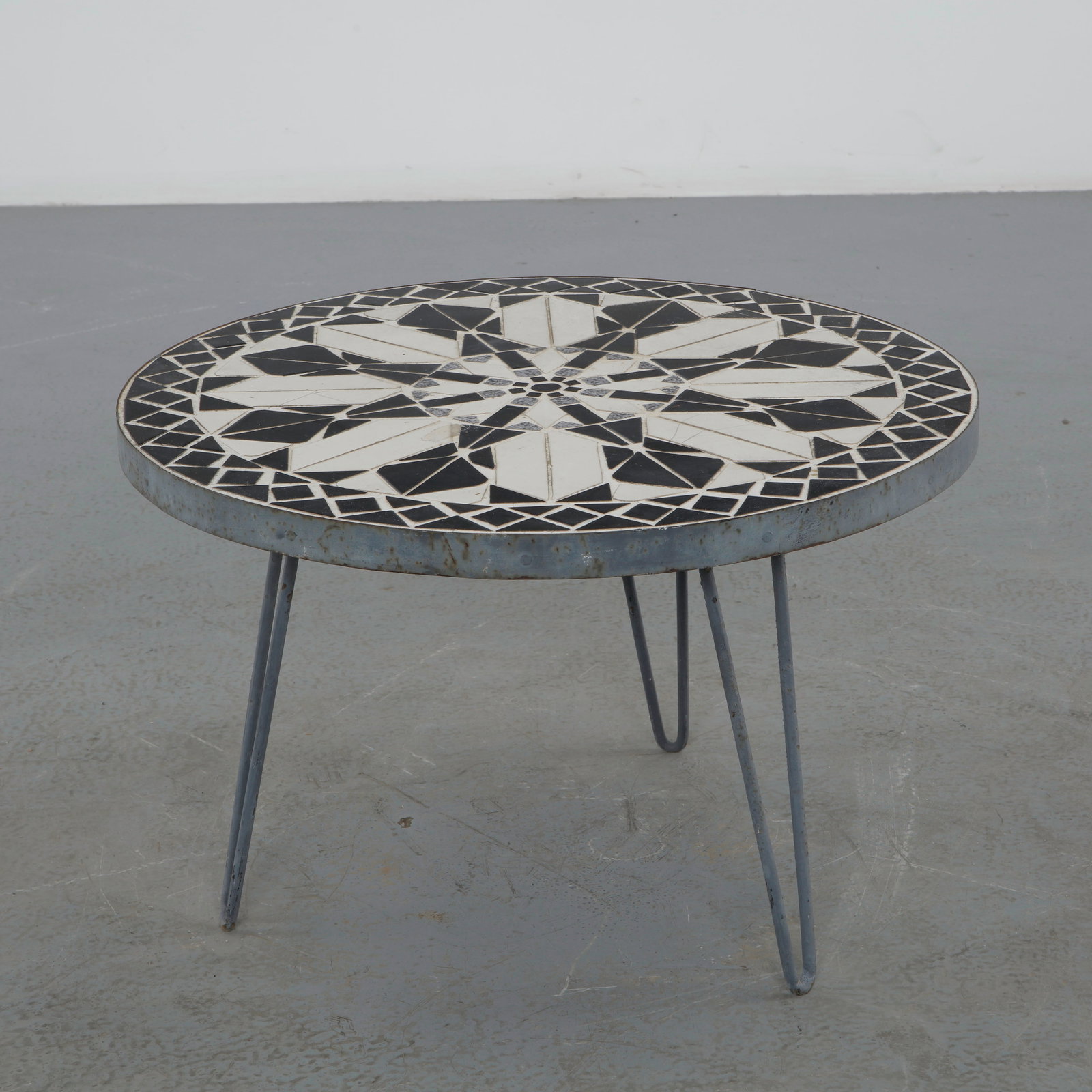 Round Black and White Mosaic Coffee Table, 1960s: Round mosaic coffee table featuring a striking black and white geometric pattern set within a steel frame on hairpin legs. The bold graphic composition and minimalist silhouette create a timeless