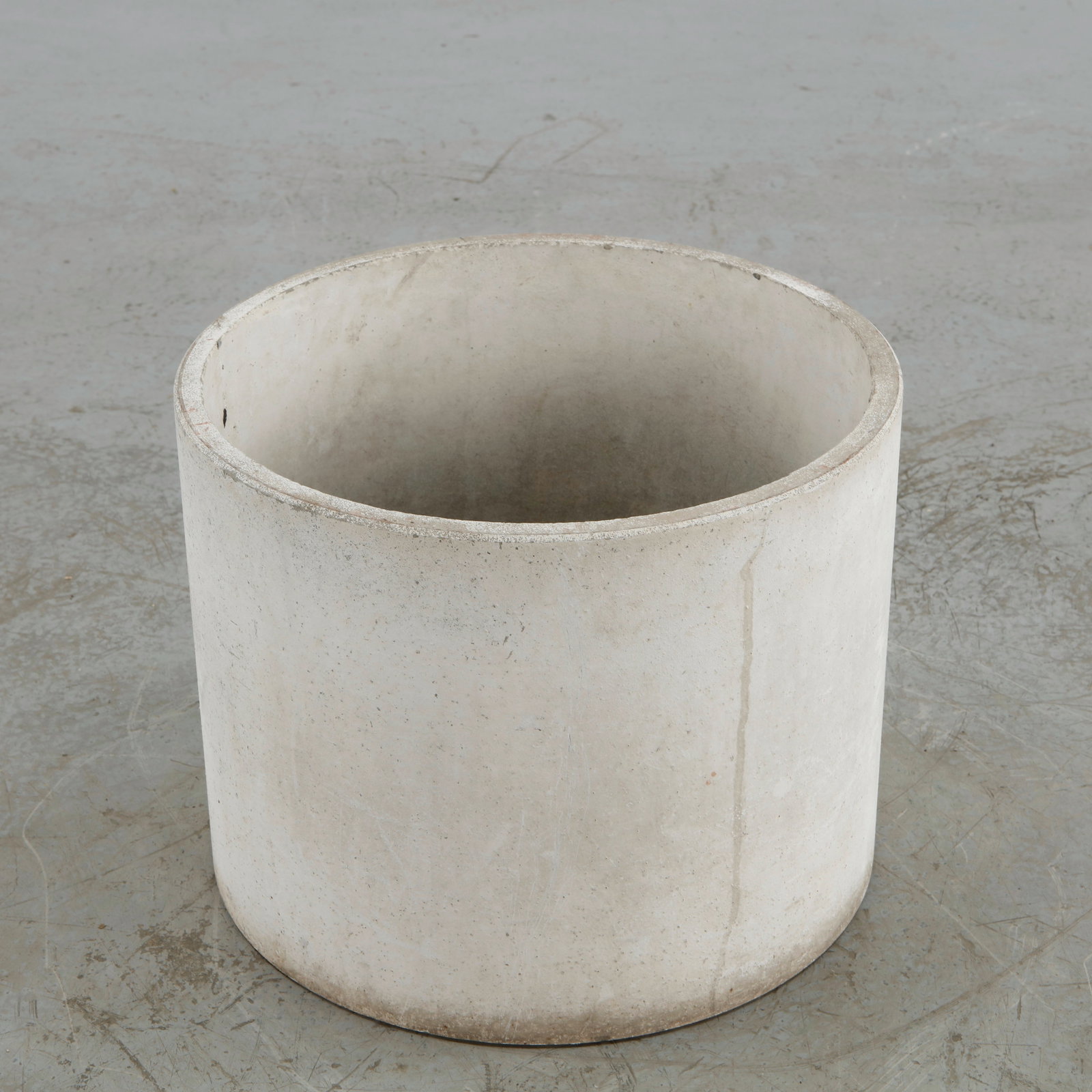 Willy Guhl, Round Planter, 1960s: A minimalist concrete planter by Willy Guhl, distinguished by its pure cylindrical silhouette and substantial proportions. Its unadorned construction and aged mineral surface embody the