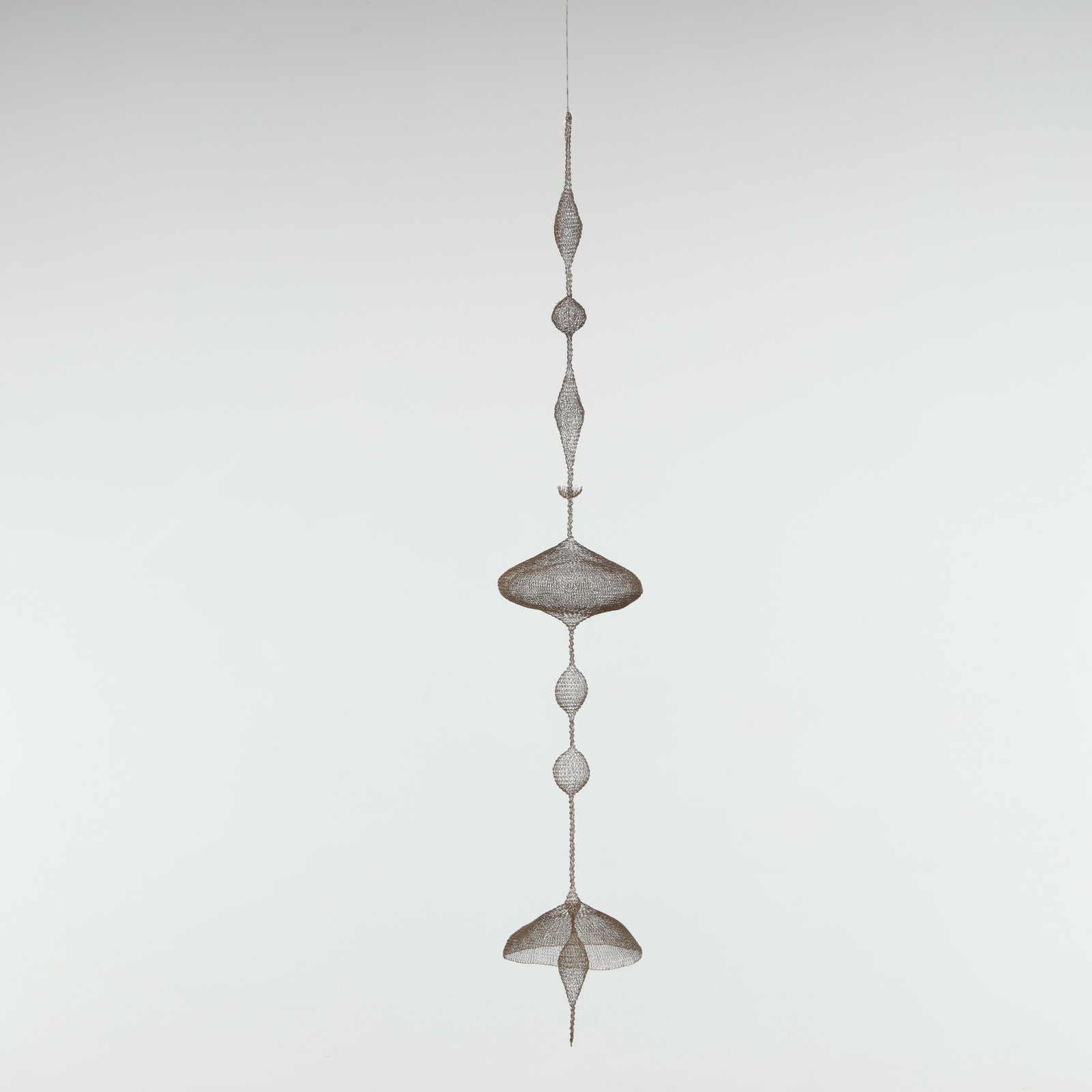 Noe Raya, Wire Brass Sculpture: Unnamed, is an intuitive, long-hanging wire sculpture driven by pure form, proportion, and balance. Hand-crafted from thin brass wire using wire looping techniques inspired by Ruth Asawa, the piece