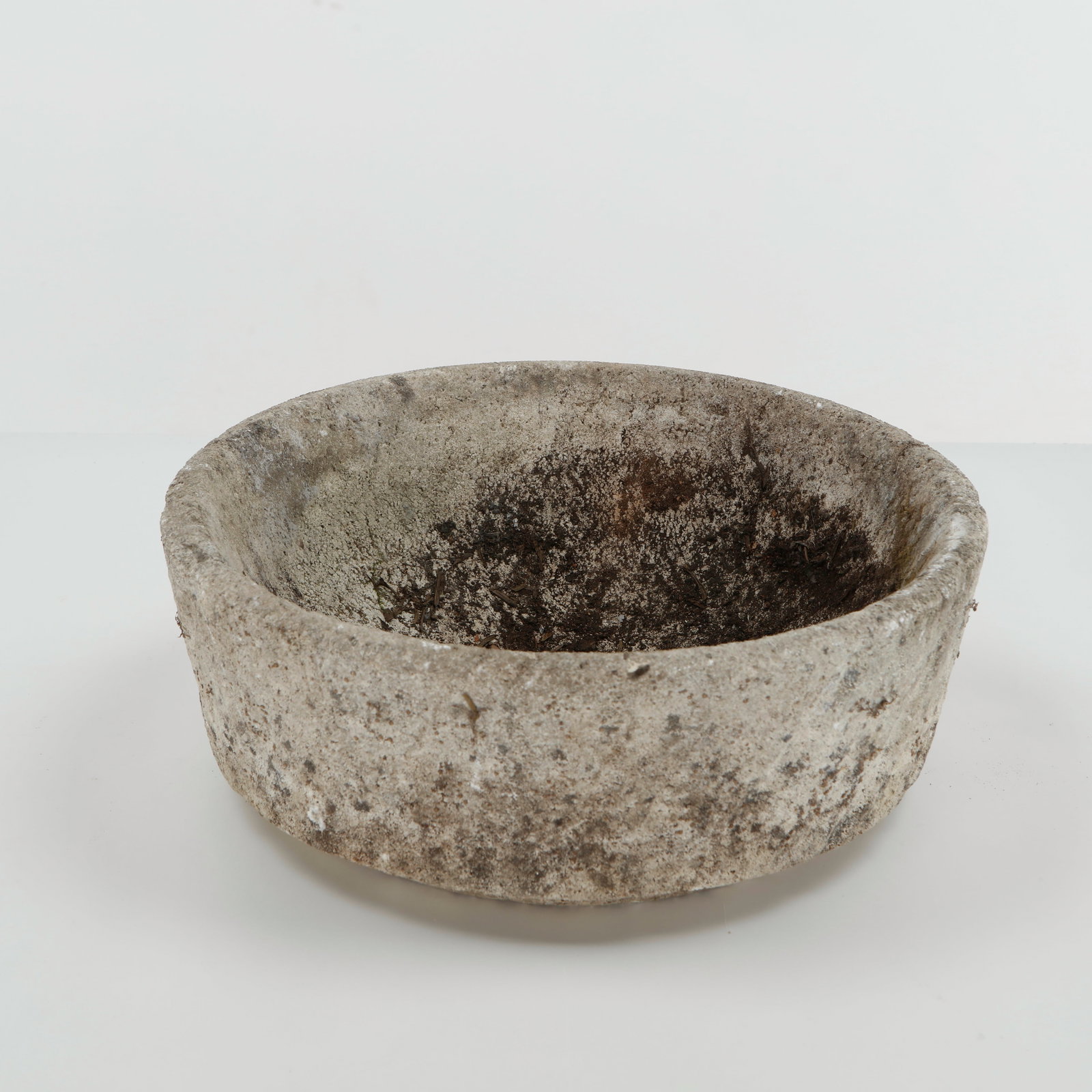 Round Stone Planter, 1960s: Substantial round planter executed in cast stone, featuring a simple circular form and softly rounded walls. Its naturally weathered surface lends the piece an austere, architectural presence suited