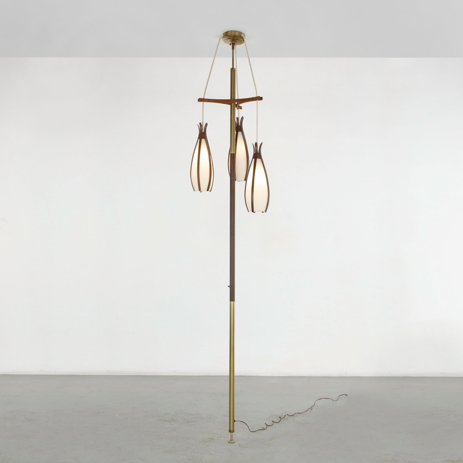 Three Light Tension Floor Lamp, 1960s: Striking floor to ceiling tension lamp secured between the floor and ceiling, with a slender brass stem supporting three elongated sculptural shades at staggered heights. The ingenious tension