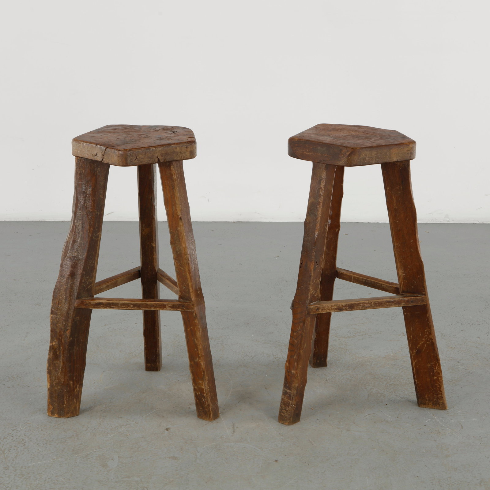 Olavi Hanninen, Pair of Elm Stools, 1960s: A refined pair of stools by Olavi Hanninen, crafted in solid elm and distinguished by thick polygonal seats supported by splayed legs. Their bold geometry, tactile grain, and robust construction exemp