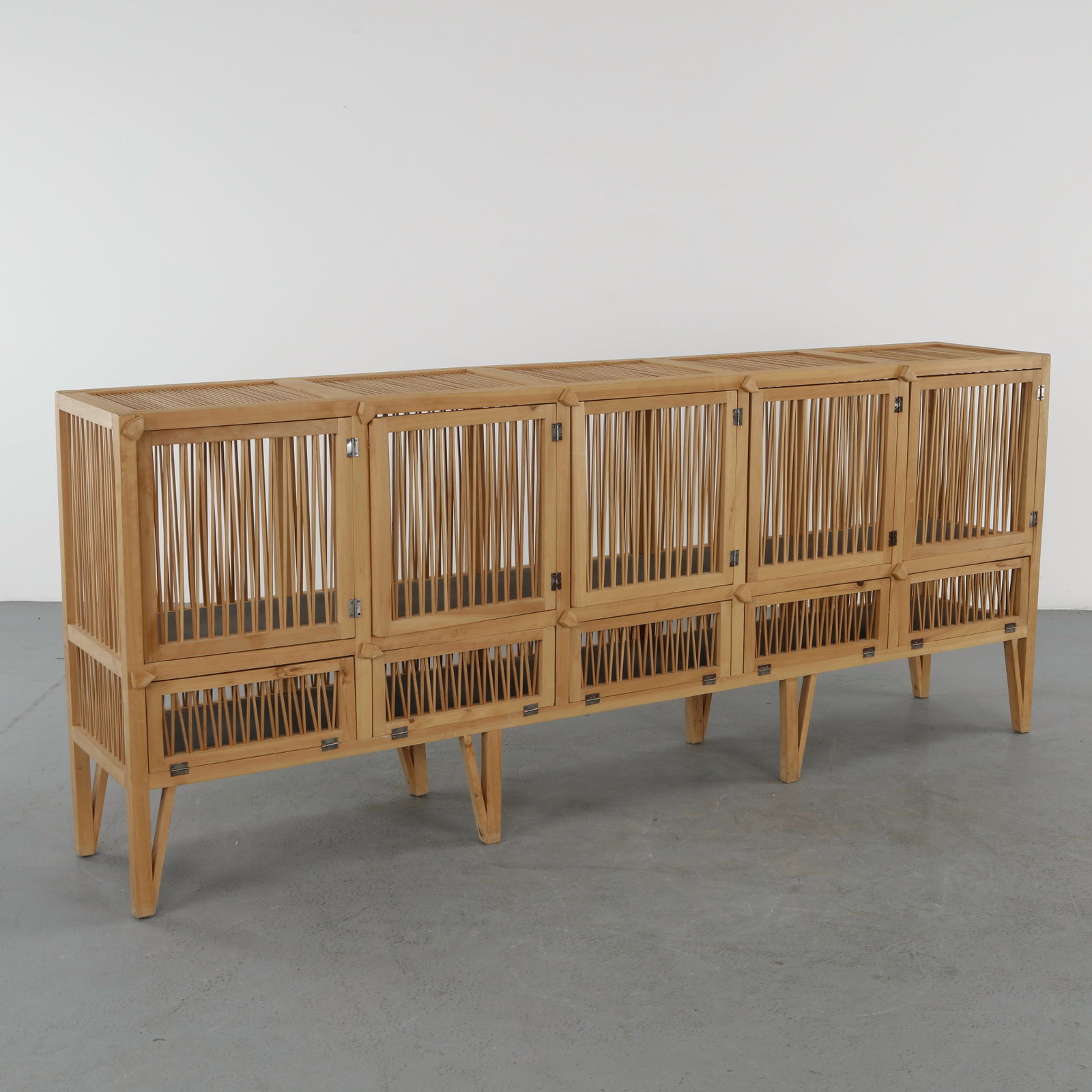 Large Wood Sideboard, 1960s: Featuring an elongated form with slatted doors and a raised structure on tapered legs. The clean lines and natural materiality reflect mid century modern craftsmanship. Height: 39.5 in. Length: 96 in.