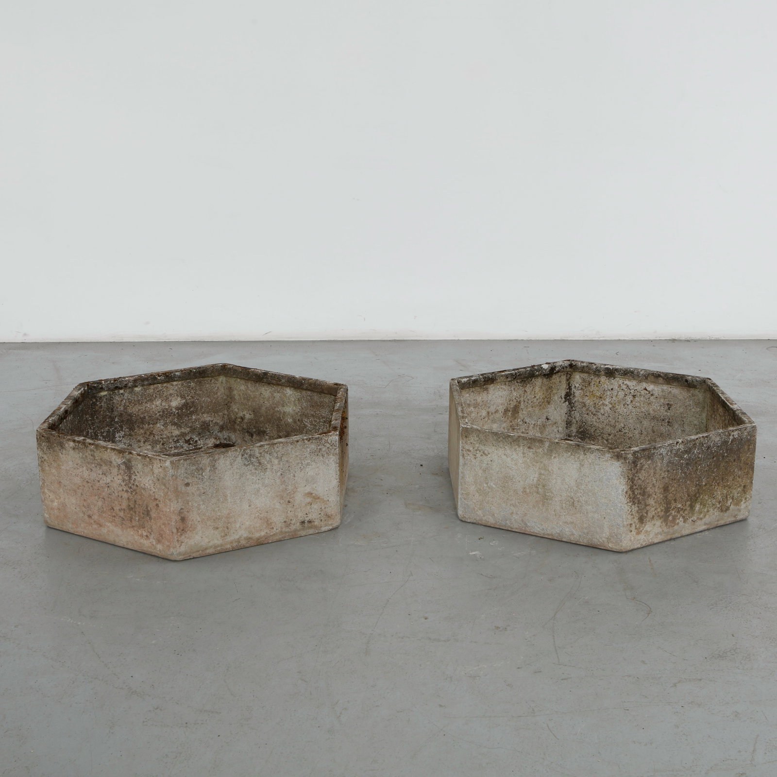 Willy Guhl, Pair of Monumental Hexagonal Planters, 1960s: A pair of concrete hexagonal planters designed by Swiss designer Willy Guhl. Its sculptural form and weathered patina give it a timeless industrial aesthetic creating an architectural presence