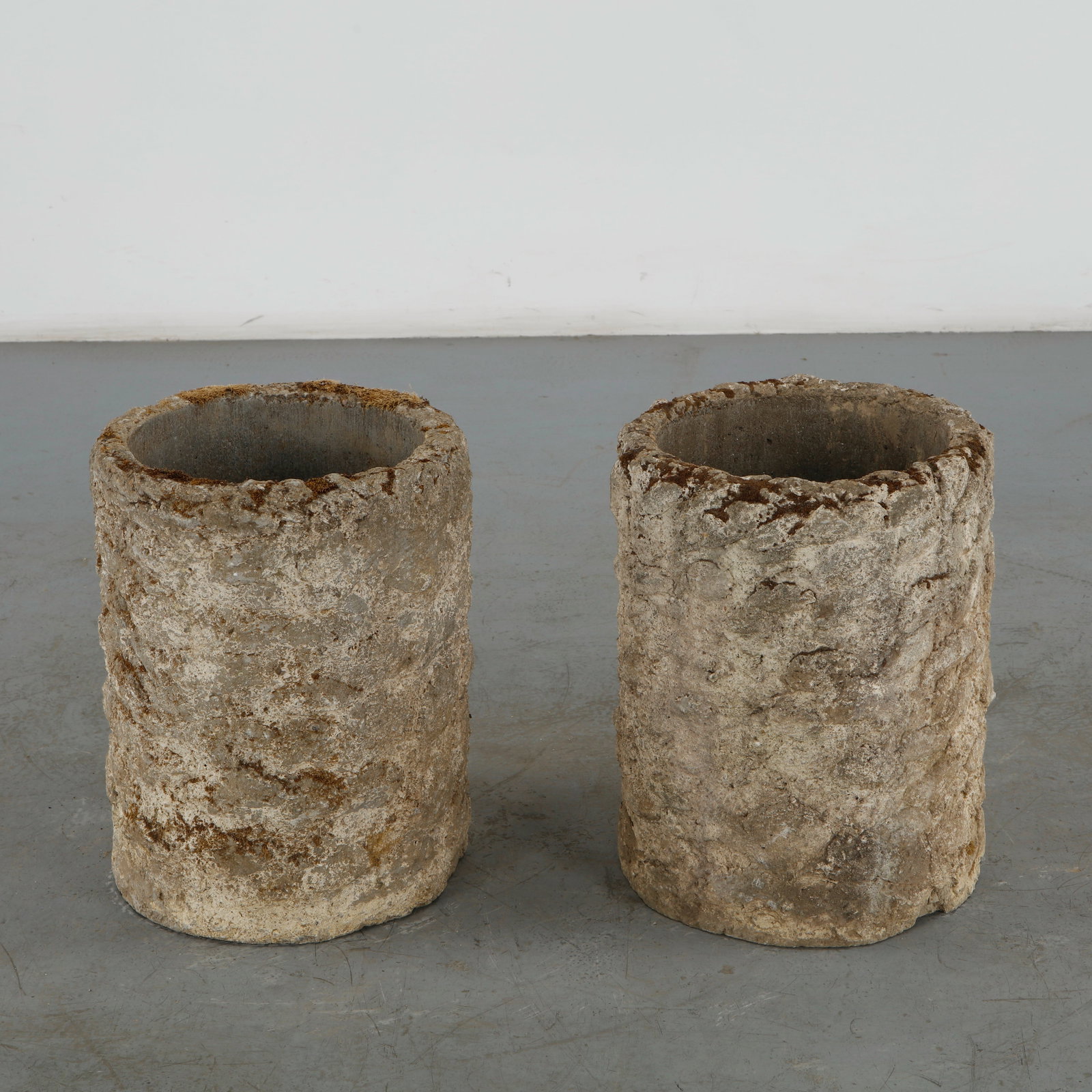 Pair of Large Stone Planters, 1960s: This pair of mid-century modern brutalist planters features an organic texture that mimics weathered stone or tree bark. The heavily cratered and tactile surface replicates the raw, unrefined