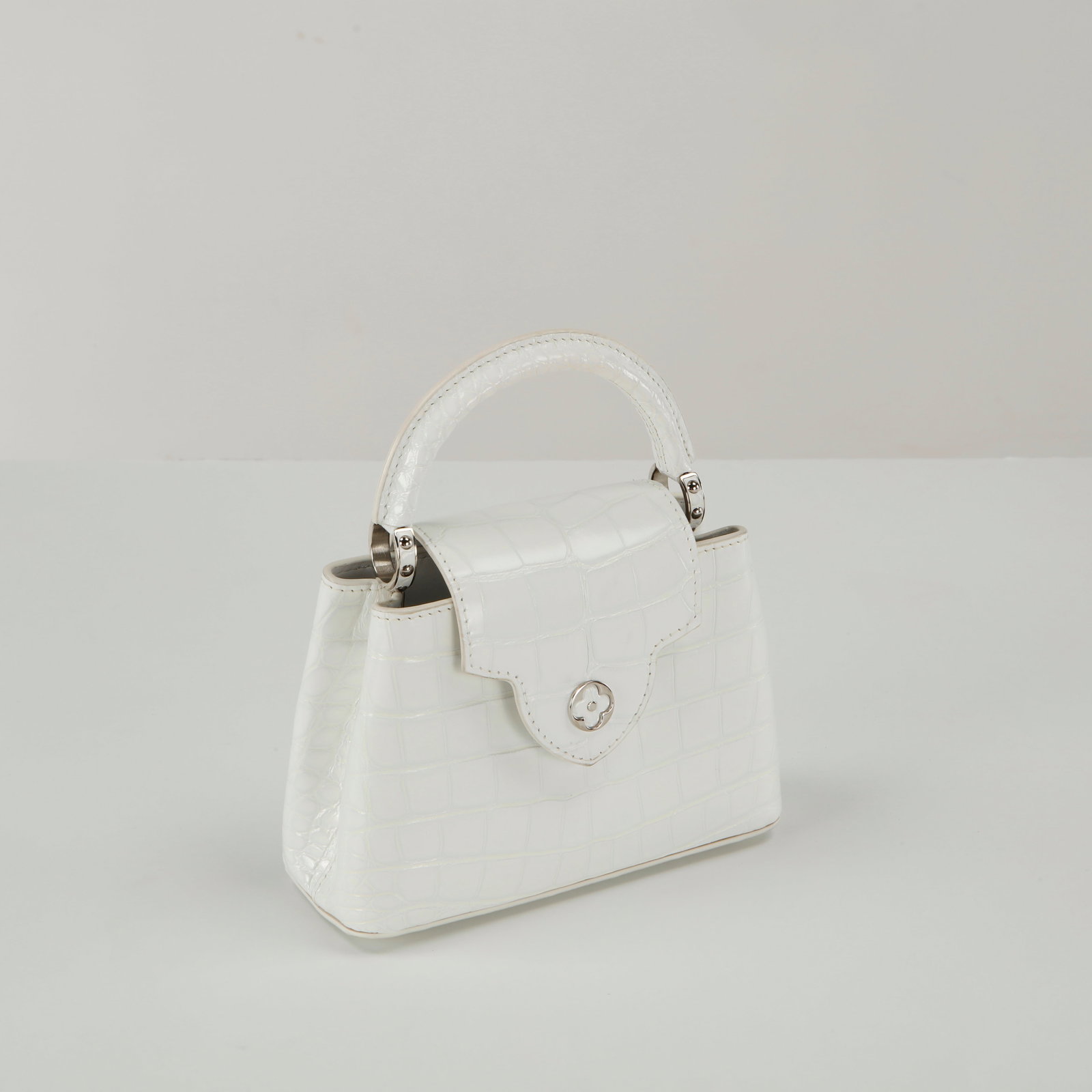Louis Vuitton, Capucines crocodile handbag: This Louis Vuitton Capucines Mini in shiny white alligator/crocodile leather with silver hardware is an ultra-luxurious, architectural masterpiece from the house's exclusive Haute Maroquinerie