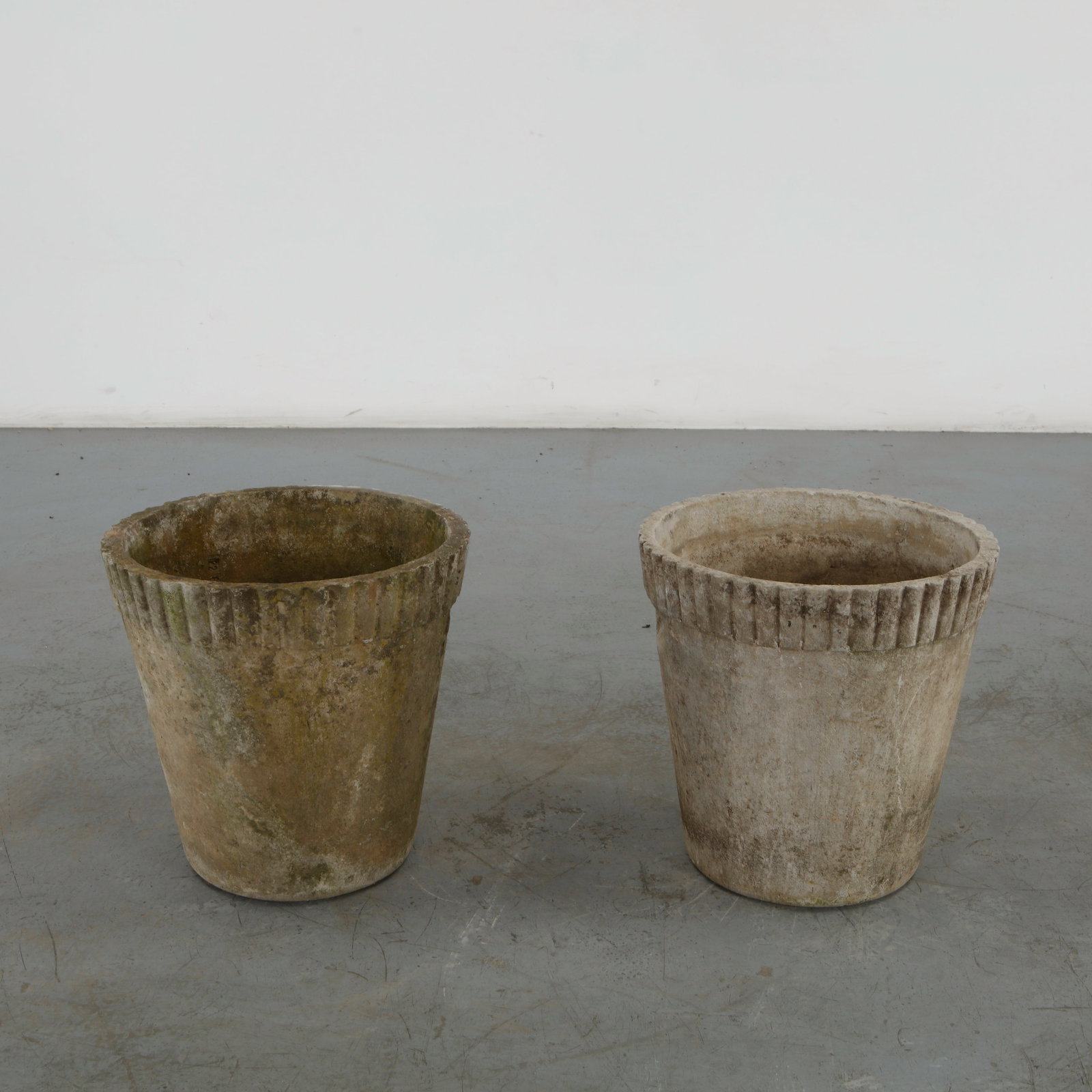 Willy Guhl, Pair of Round Planters, 1960s: Classic 1960s round planters by Willy Guhl, with ribbed detailing along the rim. Timeless silhouettes for elegant garden design. Height: 15 in. Diameter: 15 in. Condition Wear commensura