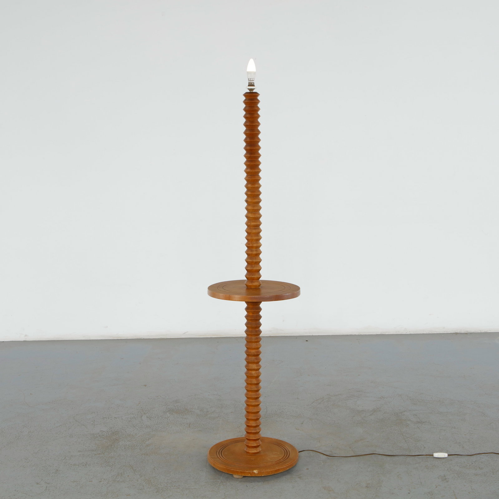 Charles Dudouyt, Carved Wood Floor Lamp with Circular Shelf, 1940s: This specific Charles Dudouyt turned wood floor lamp is an authentic piece of 1940s French brutalist design. It features an integrated table shelf, highlighting his signature architectural approach to