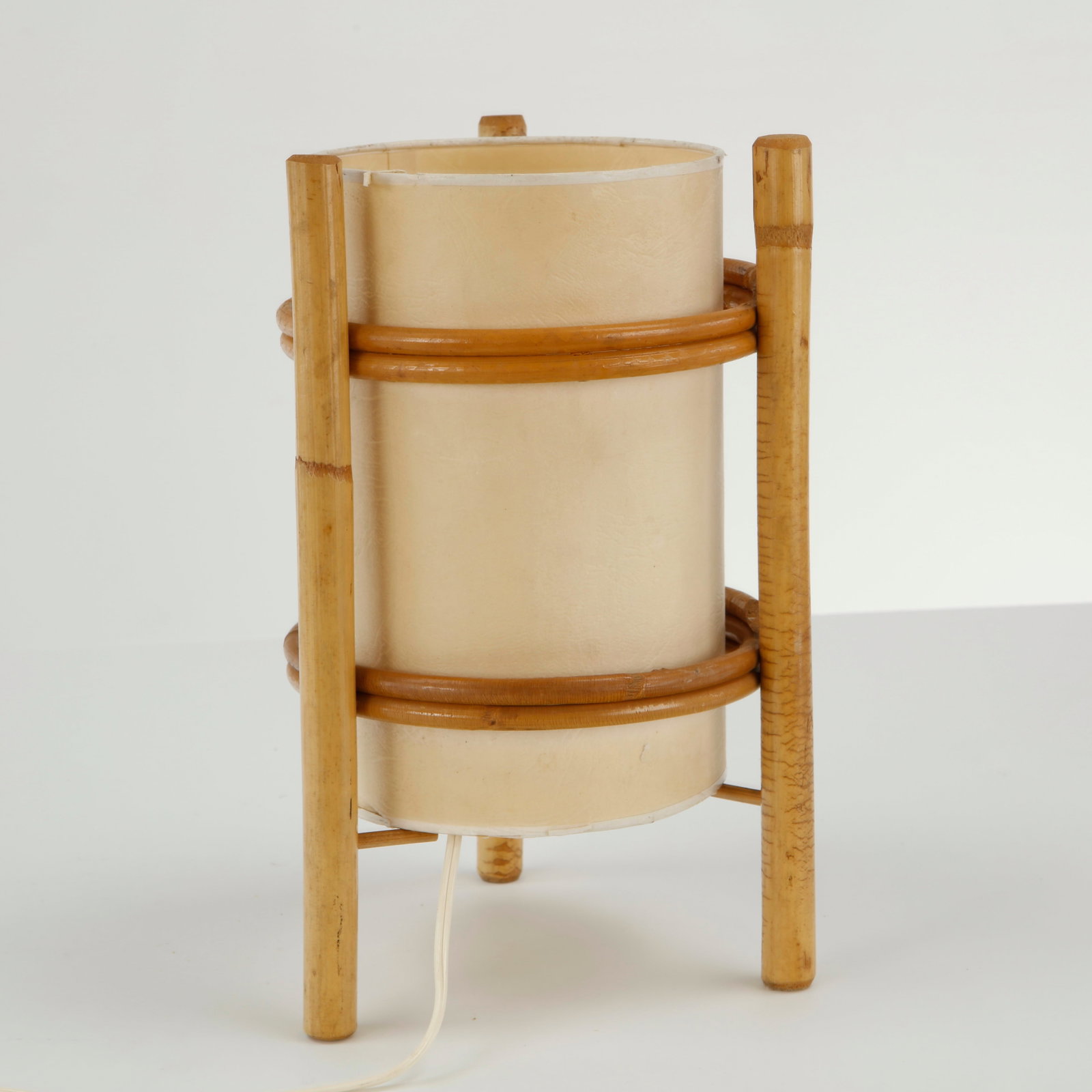 Louis Sognot, Rattan Cylindrical Table Lamp, 1960s: This bamboo table lamp by Louis Sognot is a beautifully minimalist example of 1960s French modern design. Working. European Plug Height: 11 in. Diameter: 7 in. Condition Good vintage con