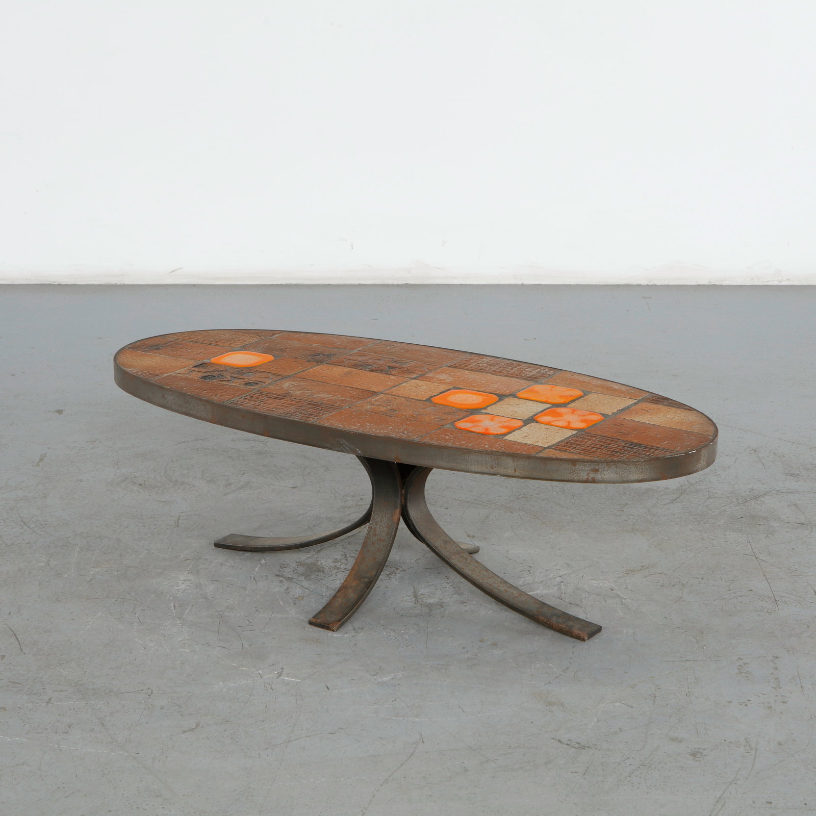 Jean Jaffeux, Lava Stone, Ceramic, and Steel Coffee Table, 1960s: This oval enameled lava stone and ceramic tile coffee table designed by French master ceramicist Jean Jaffeux is a stunning example of mid-century French artisan craftsmanship. It beautifully pairs ru