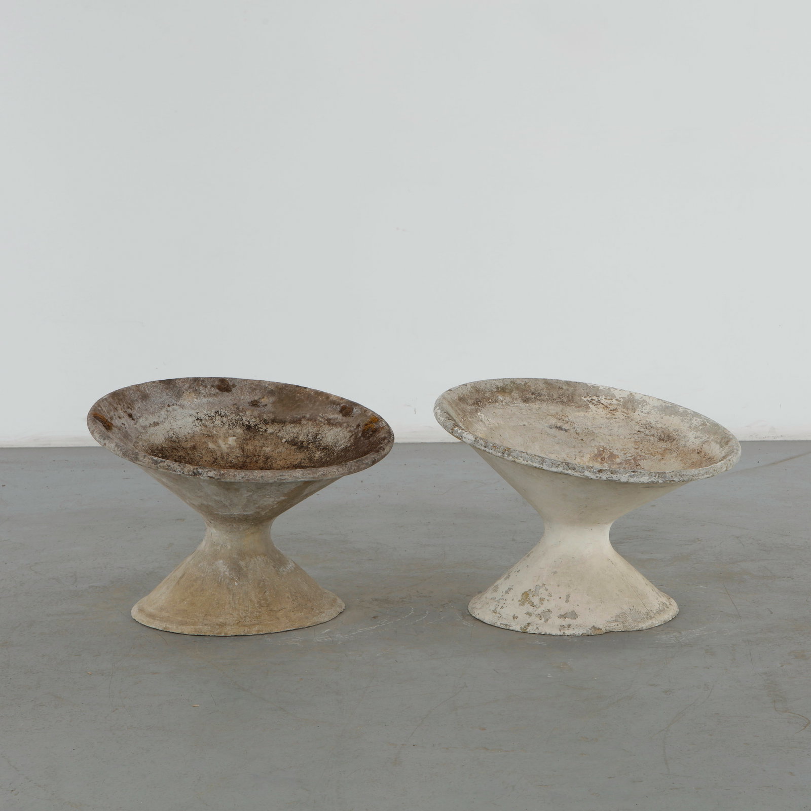 Willy Guhl, Pair of Off Kilter Planters, 1960s: A pair of rare asymmetrical planters by Willy Guhl, featuring a bold modernist design. TOP Diameter: 25 in. BASE Diameter: 17 in. Height: 18 in. Condition Wear commensurate with age and