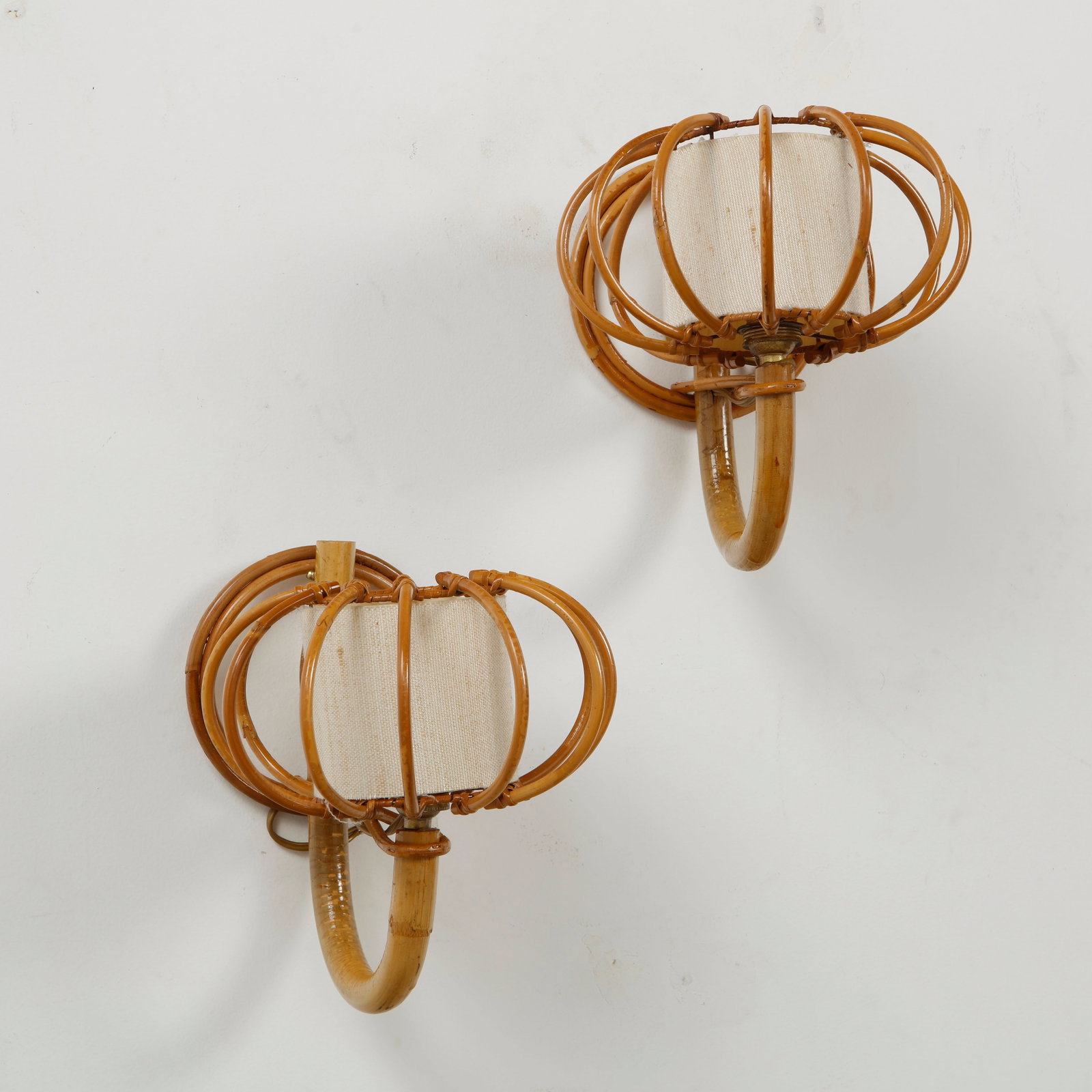 Louis Sognot, Pair of Rattan and Bamboo Sconces, 1960s: This pair of woven rattan wall sconces by Louis Sognot is an iconic example of 1960s French mid-century modern design. Based in France, Sognot became world-renowned for his ability to transform organi