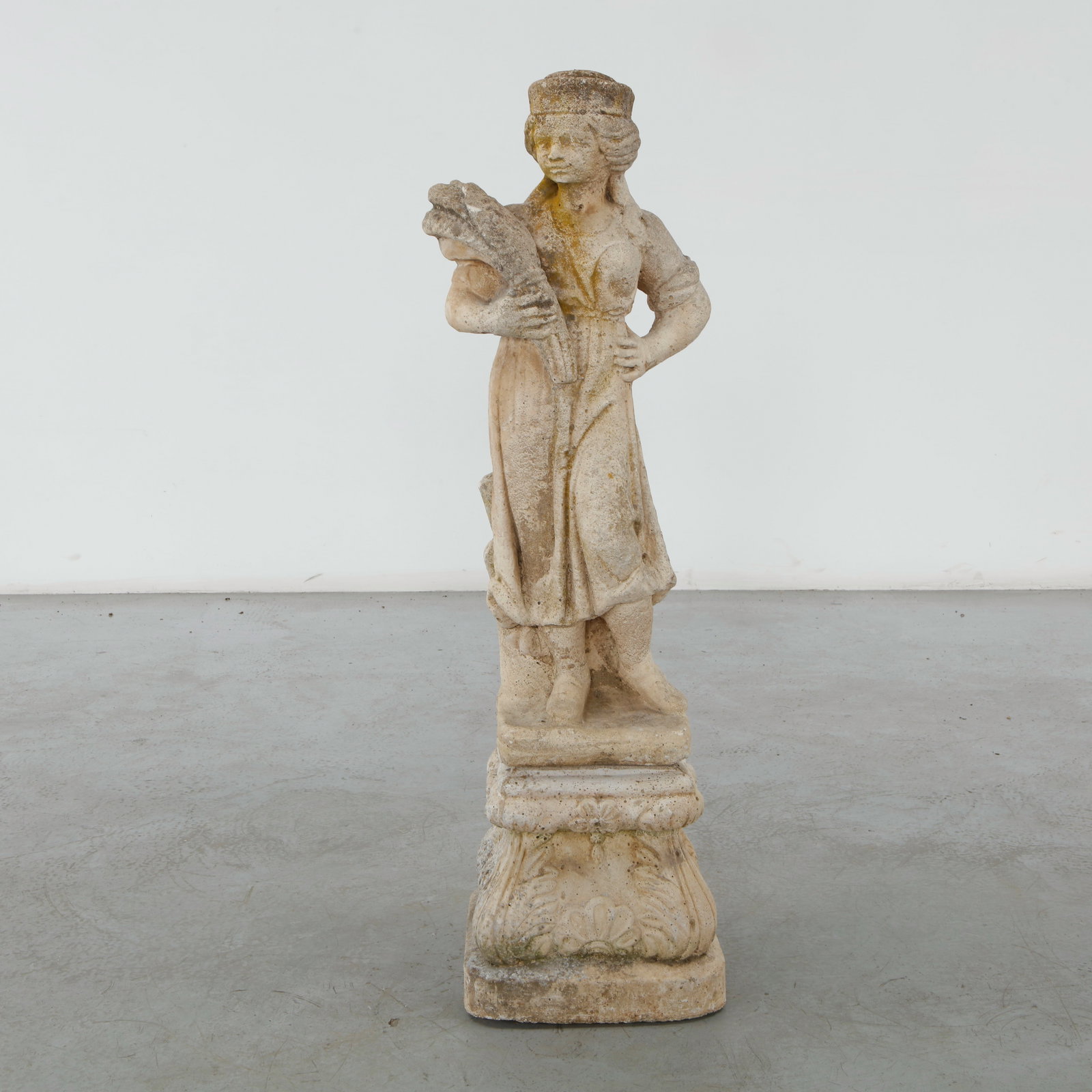 Classical Garden Statue of a Maid, 20th Century: Graceful cast stone garden sculpture portraying a young maiden holding a bouquet of flowers. Richly detailed drapery and a naturally aged surface evoke the enduring charm of traditional European garde