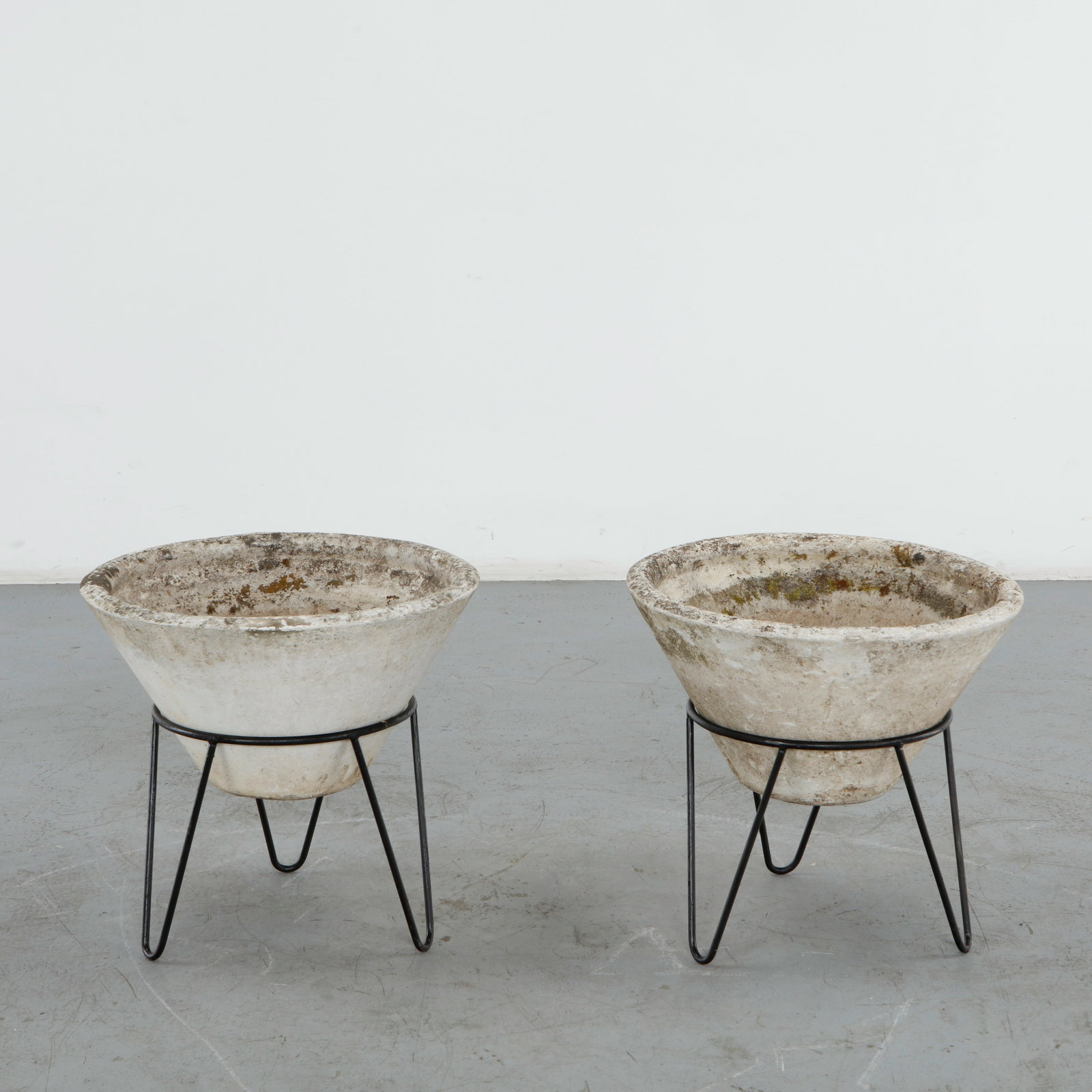 Willy Guhl, Pair of Conical Planters on Stands, 1960s: Iconic Willy Guhl silhouettes in compact form, these conical planters rest atop minimalistic metal stands, weathered yet timeless. Height: 19.5 in. Diameter: 22 in. Condition Wear