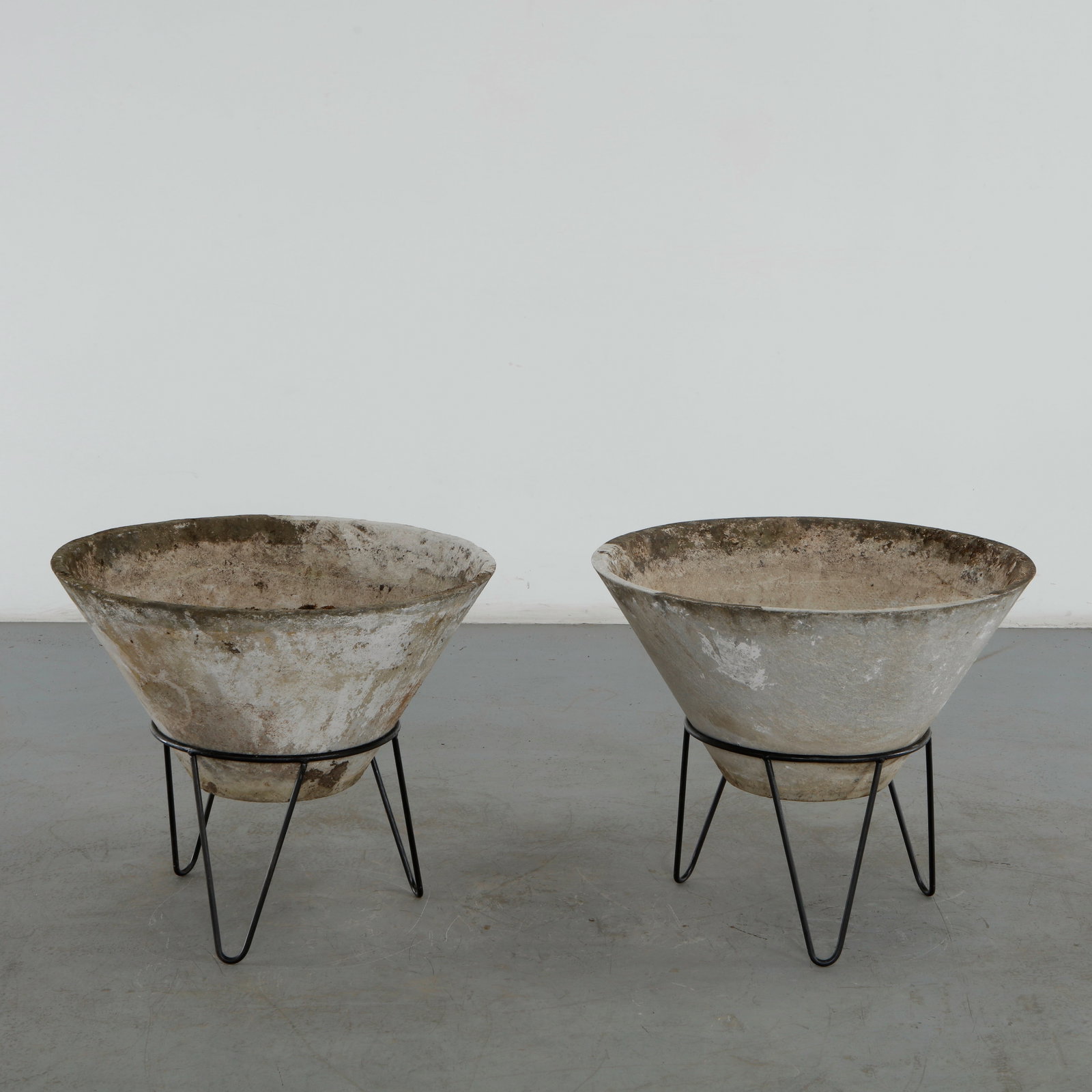 Willy Guhl, Pair of Large Conical Planters on Stands, 1960s: Iconic Willy Guhl silhouettes in large form, these conical planters rest atop minimalistic metal stands, weathered yet timeless. Height: 24 in. Diameter: 28.5 in. Condition Wear
