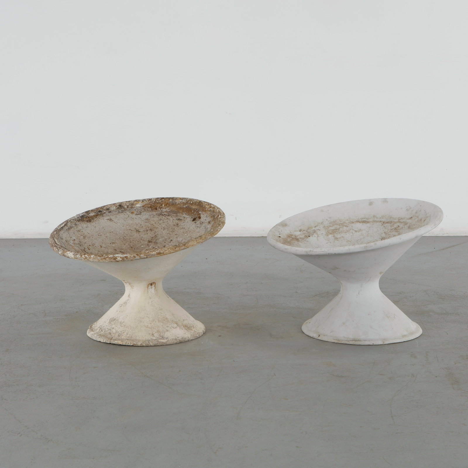 Willy Guhl, Pair of Off Kilter Planters, 1960s: A pair of rare asymmetrical planters by Willy Guhl, featuring a bold modernist design. TOP Diameter: 25 in. BASE Diameter: 17 in. Height: 18 in. Condition Wear commensurate with age and 