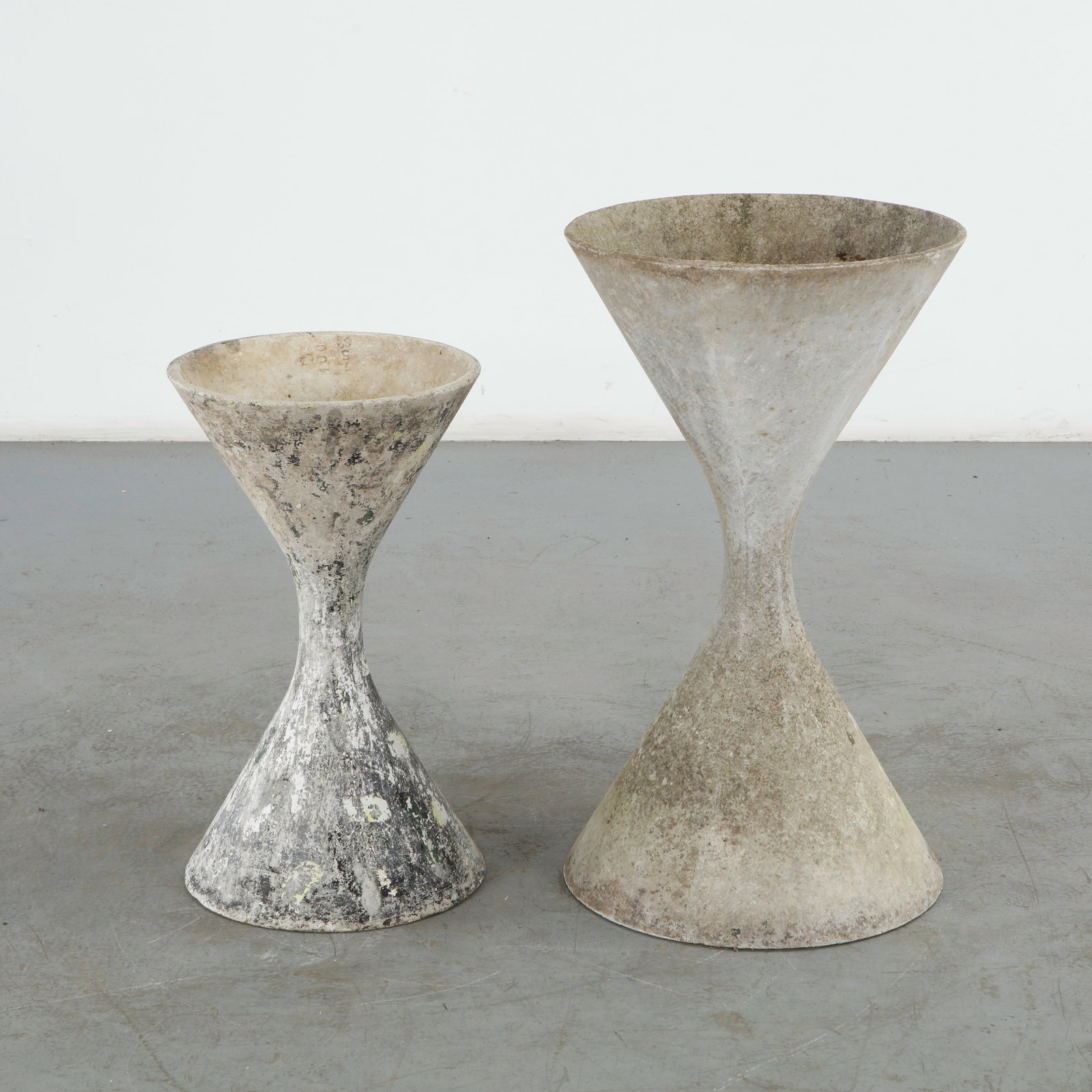 Willy Guhl, Pair of Medium and Small Diabolo Planters, 1960s: A sculptural pair of medium and small Diabolo planters by Willy Guhl. Crafted in fiber cement for Eternit, Switzerland. Medium: Height: 32 in. Diameter: 18 in. Small: Height: 25 in. Diameter: 14.5