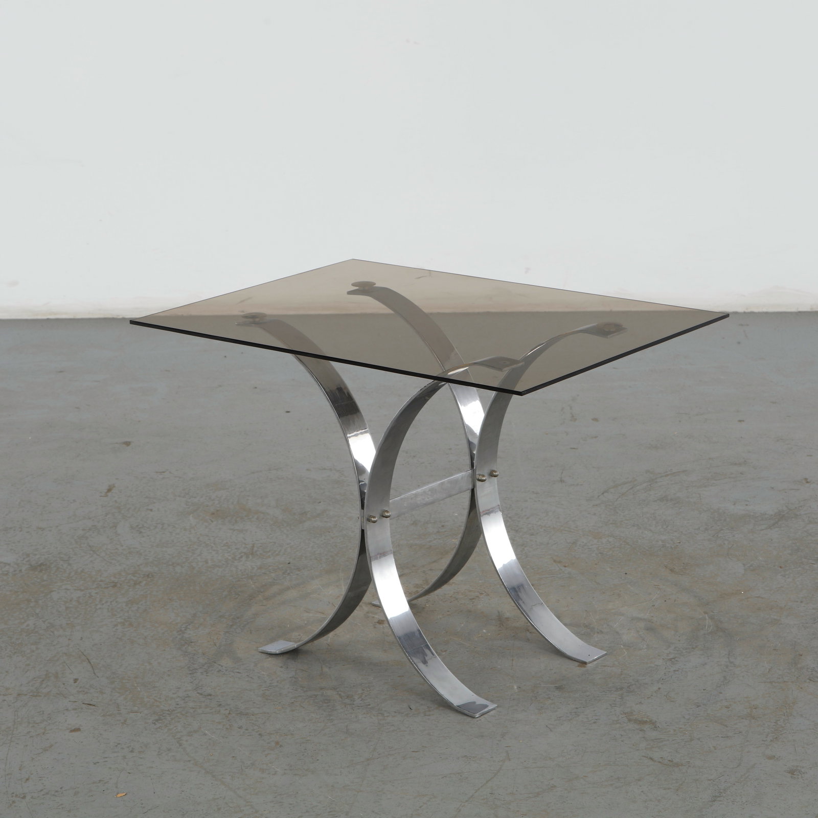 Chrome Base and Glass Top Table Attributed to Ronald Schmitt, 1960s Germany: This midcentury modern glass and chrome occasional table from the 1960s, designed in the structural style attributed to German manufacturer Ronald Schmitt. Known for high-quality engineering and
