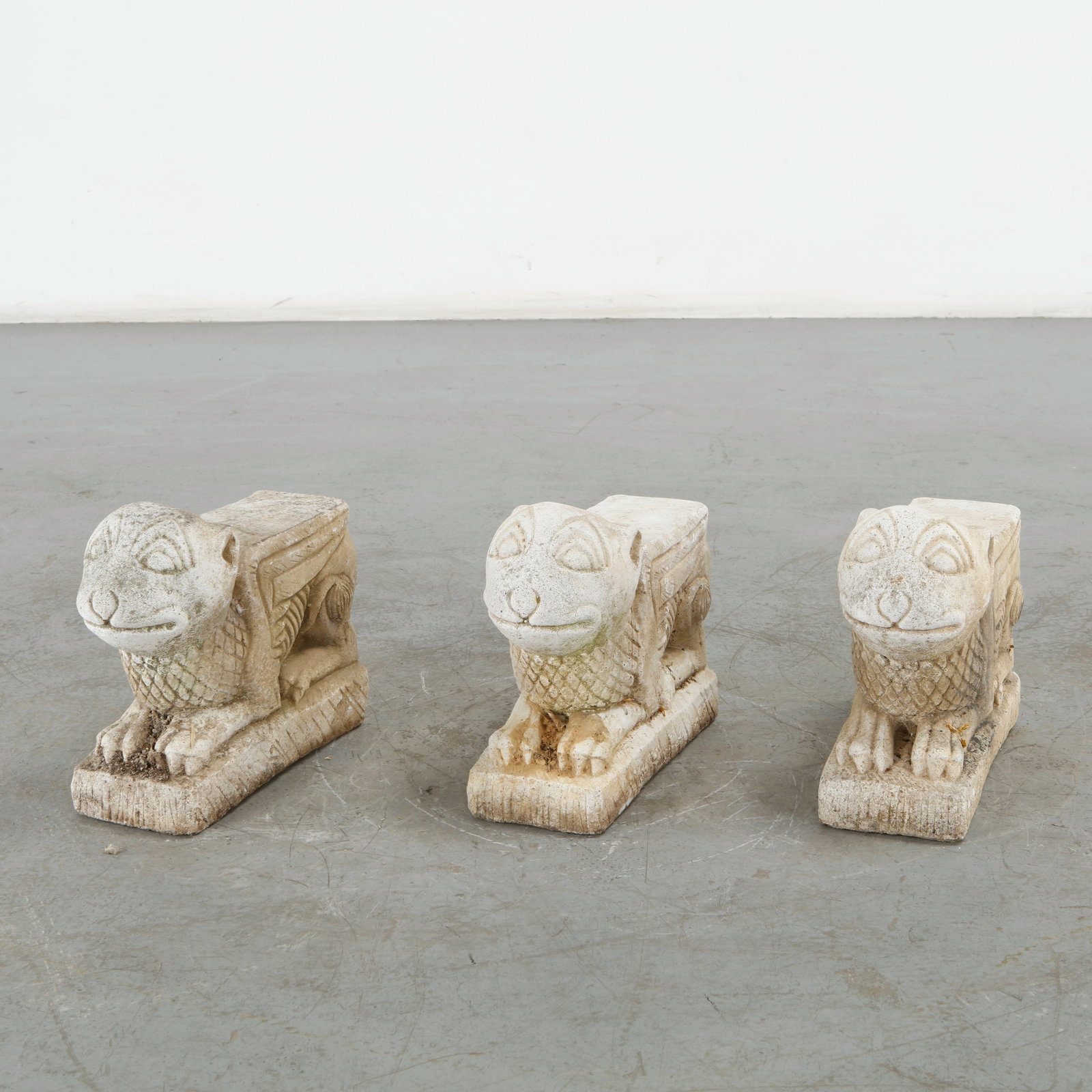 Set of Three Concrete Lion Garden Sculptures: This set of three 1960s mid-century cast concrete winged lion garden sculptures captures an exceptional Romanesque and mythological structural aesthetic. Height: 12 in. Length: 13 in. Width: 5 in.