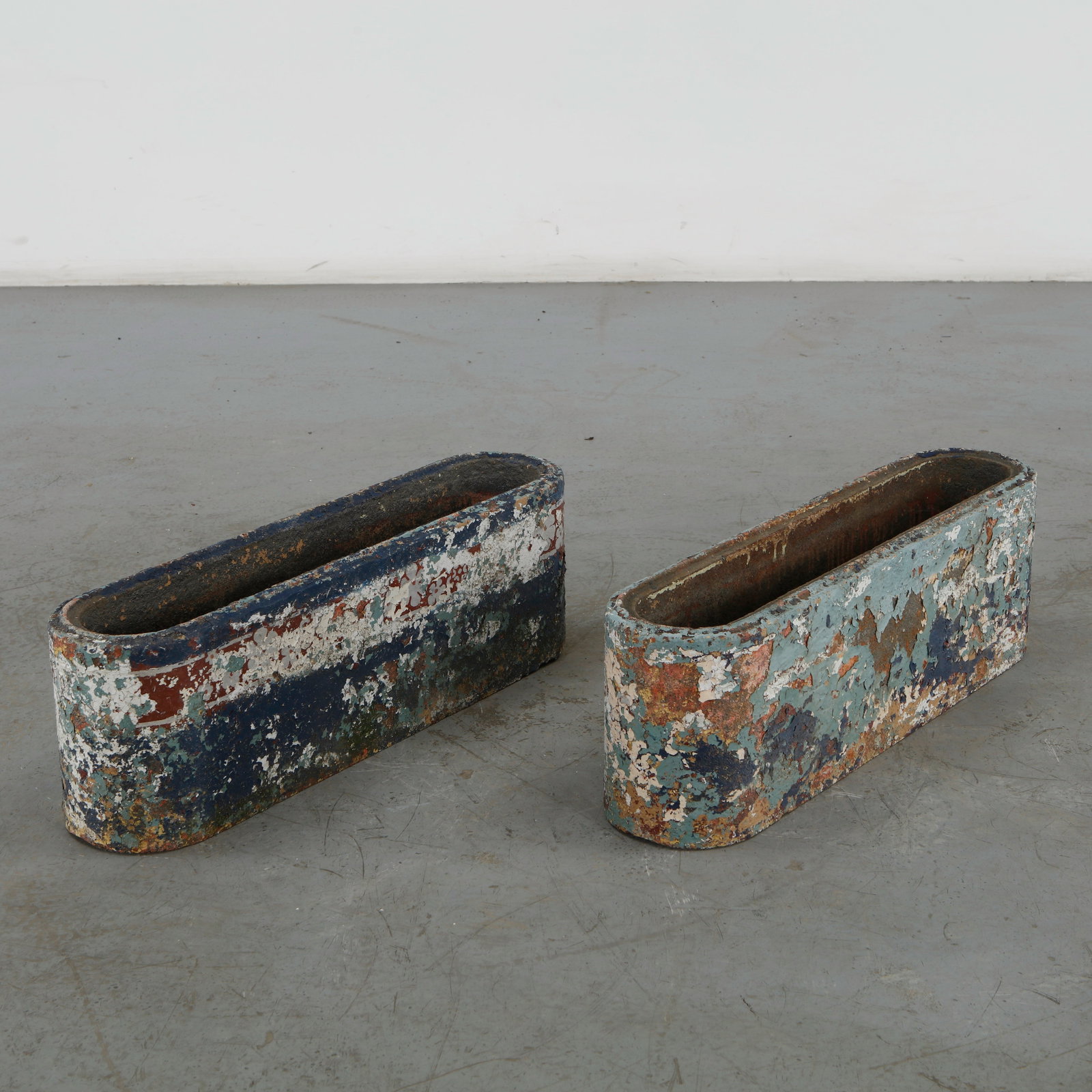 Pair of Blue Metal Trough Planters, 1960s: Designed by Swiss architect and designer Willy Guhl for Eternit this pair of metal trough planters features a distinctive "pill-shaped" or elongated oval design with smooth, rounded corners. They are