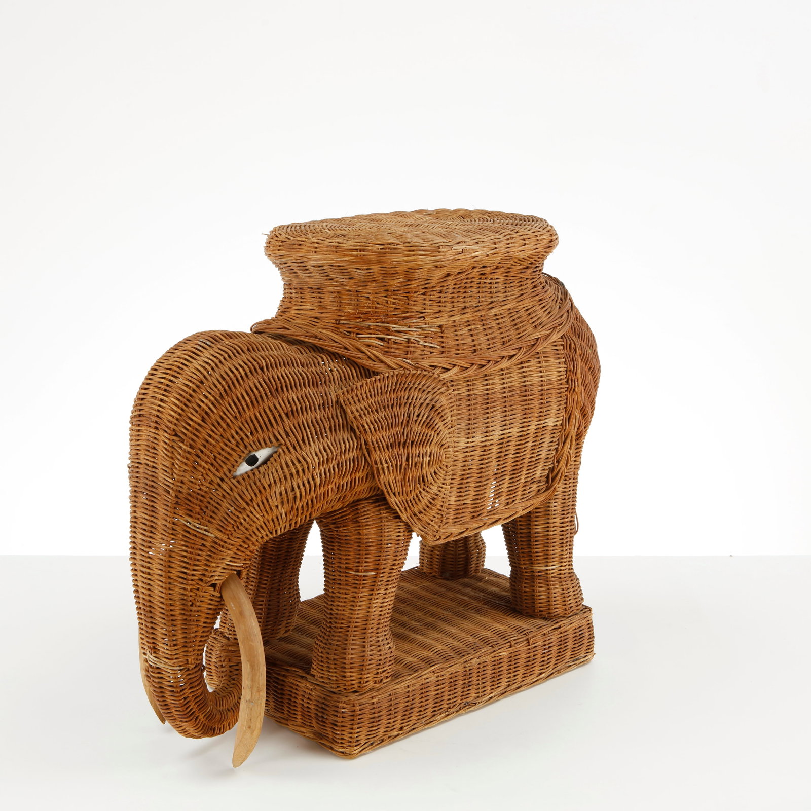 Italian Rattan Elephant Sculpture, 1970s: This piece is a vintage Mid-Century Modern woven rattan elephant plant stand or side table, designed in the playful and eclectic Hollywood Regency or Bohemian style typical of the 1960s and 1970s.