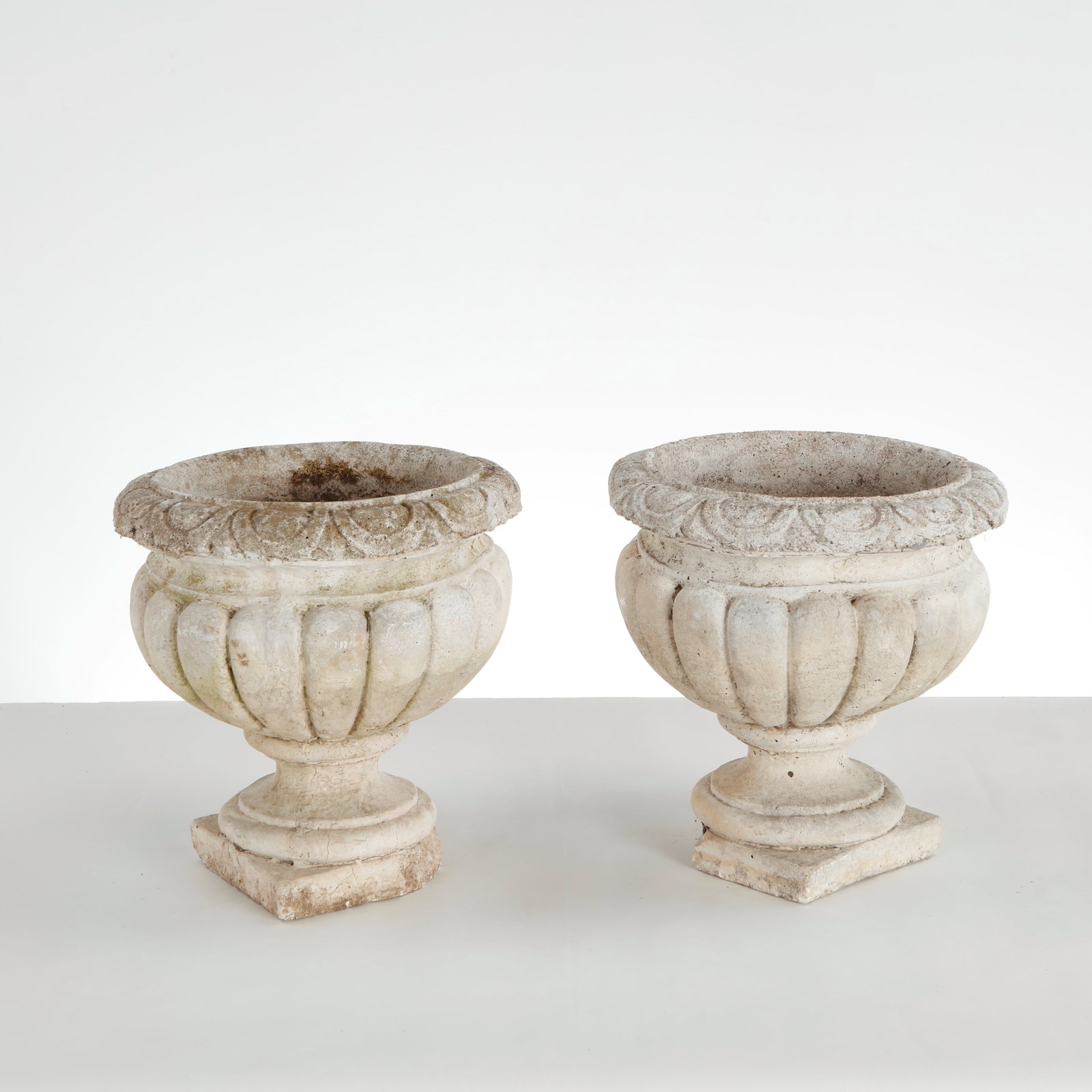 Pair of Stone Urn Planters, 1960s: This pair of vintage cast stone campana urn planters represents a highly detailed, neoclassical style of European garden ornamentation. They feature a more ornate finish and complex structural layout 