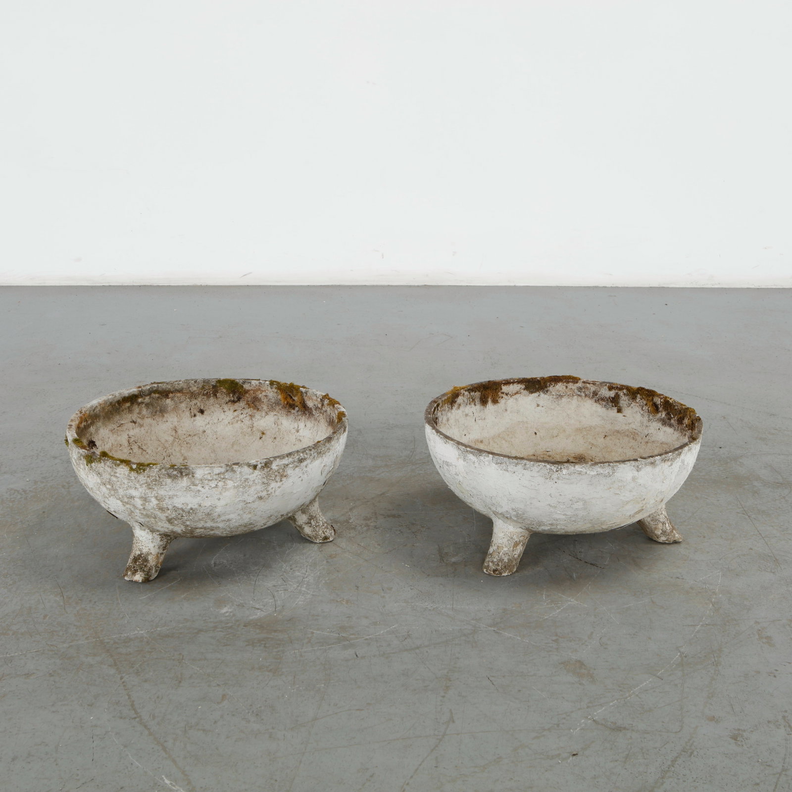 Willy Guhl, Pair of Half Cauldron Planters, 1960s: A sculptural pair of cauldron-shaped planters by Swiss designer Willy Guhl for Eternit. Resting on three feet, their compact form and beautifully weathered patina offer both charm and architectural