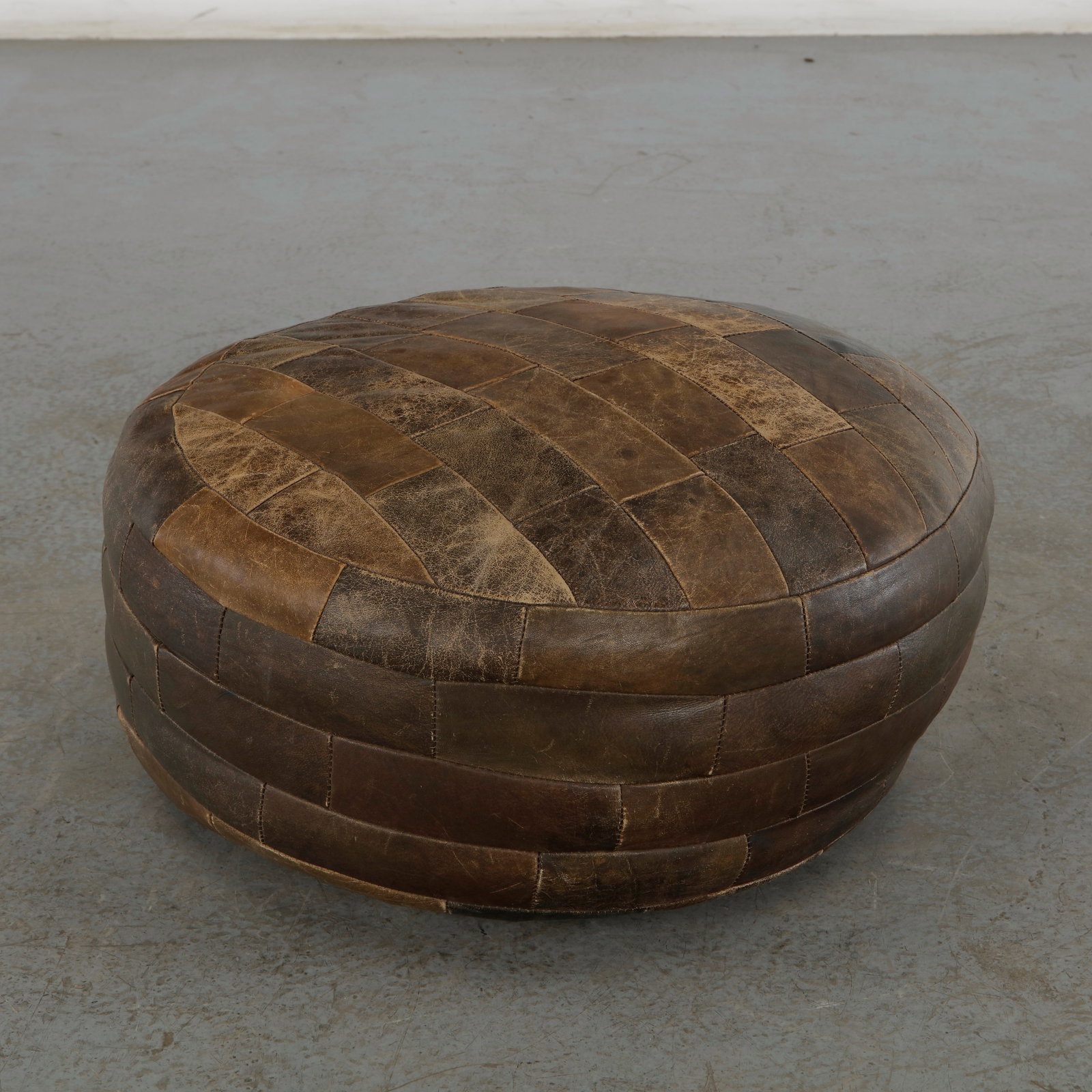 De Sede, Brown Leather Ottoman, 1960s: This brown leather patchwork ottoman is a premium piece of 1960s or 1970s Swiss modern design by De Sede. Known for world-class leather craftsmanship, this piece demonstrates the brand's ability to