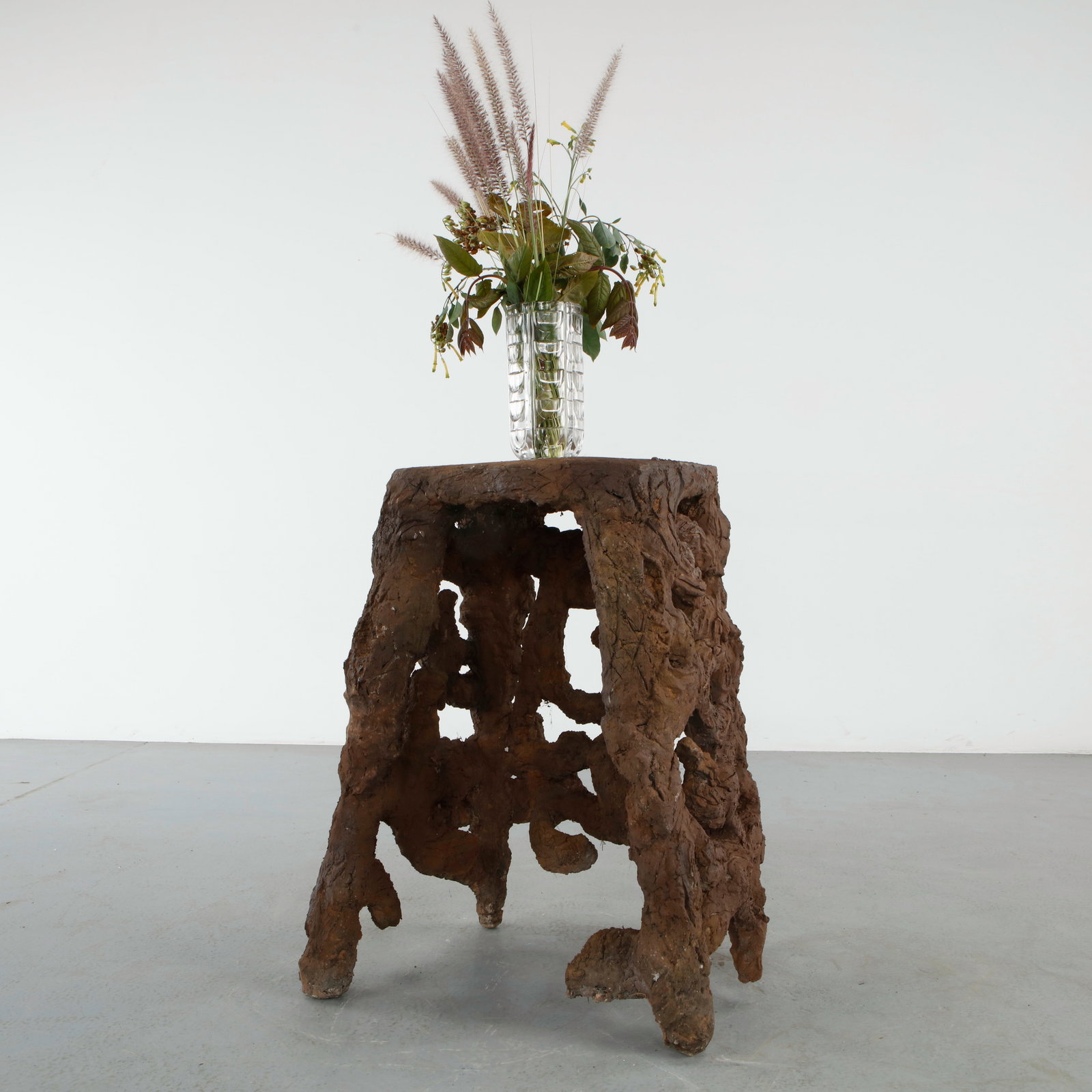 Sculptural Faux Bois Side Table: Sculptural faux bois side table executed with heavily textured organic forms beneath a circular top imitating carved wood grain. The compact silhouette embodies the whimsical character of rustic
