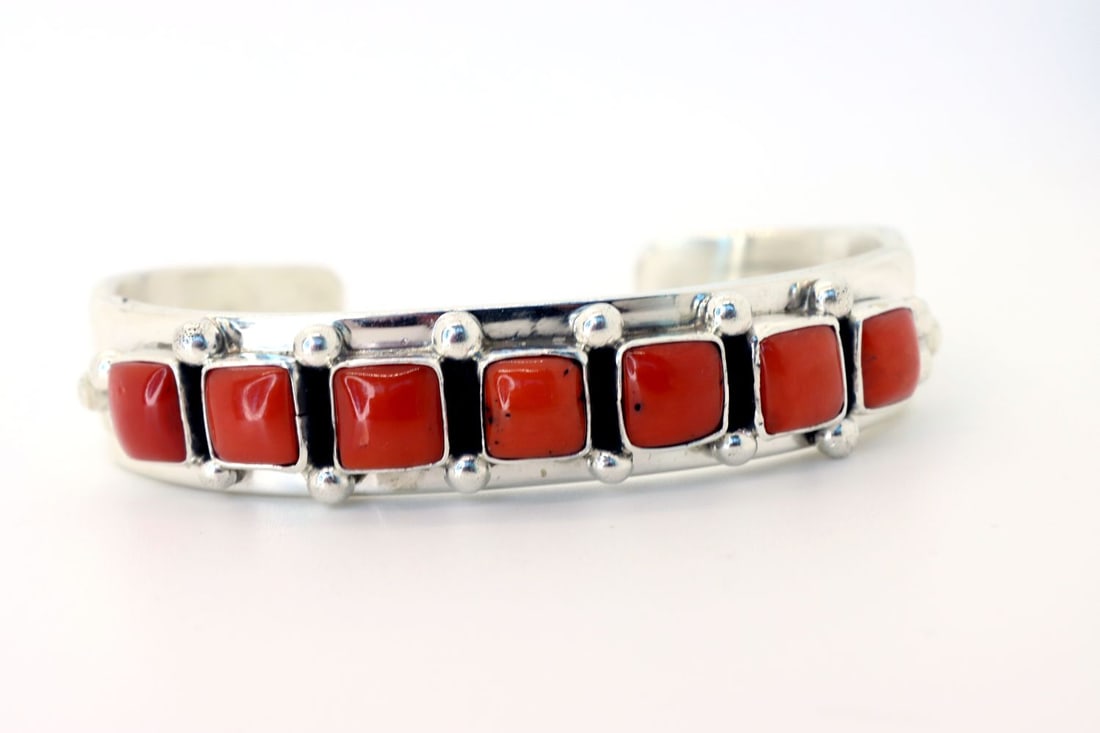 Navajo Magnificent Mediterranean Red Coral Cuff: Navajo magnificent Mediterranean red coral cuff of (5) pieces of square coral L 1/4"x 1/4"W and (18) sterling silver beads 3mm, signed by artist and master silversmith "aul Livingston". Sterling silve