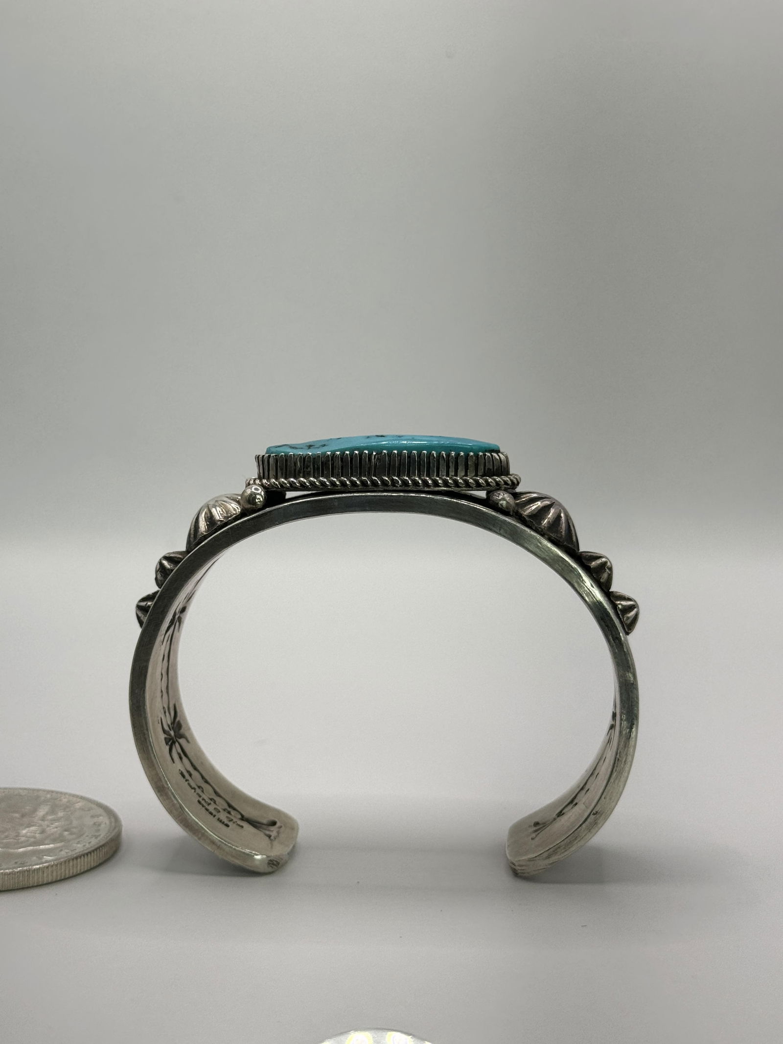 Richard Jim Bisbee Turquoise Cuff: Native American Navajo Master Silversmith Richard Jim sterling silver cuff bracelet with a Bisbee Turquoise center stone L 1 1/4" x 1/2" set in a sawtooth bezel with twisted wire, hand tooled and hand