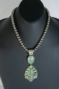 Ella Linkin Sensational Royston Pendant: Native American Navajo master silversmith Ella Linkin sensational sterling silver pendant featuring a AAAAA Royston Turquoise triangular center gemstone surrounded by twisted wire and (10) gemstones a