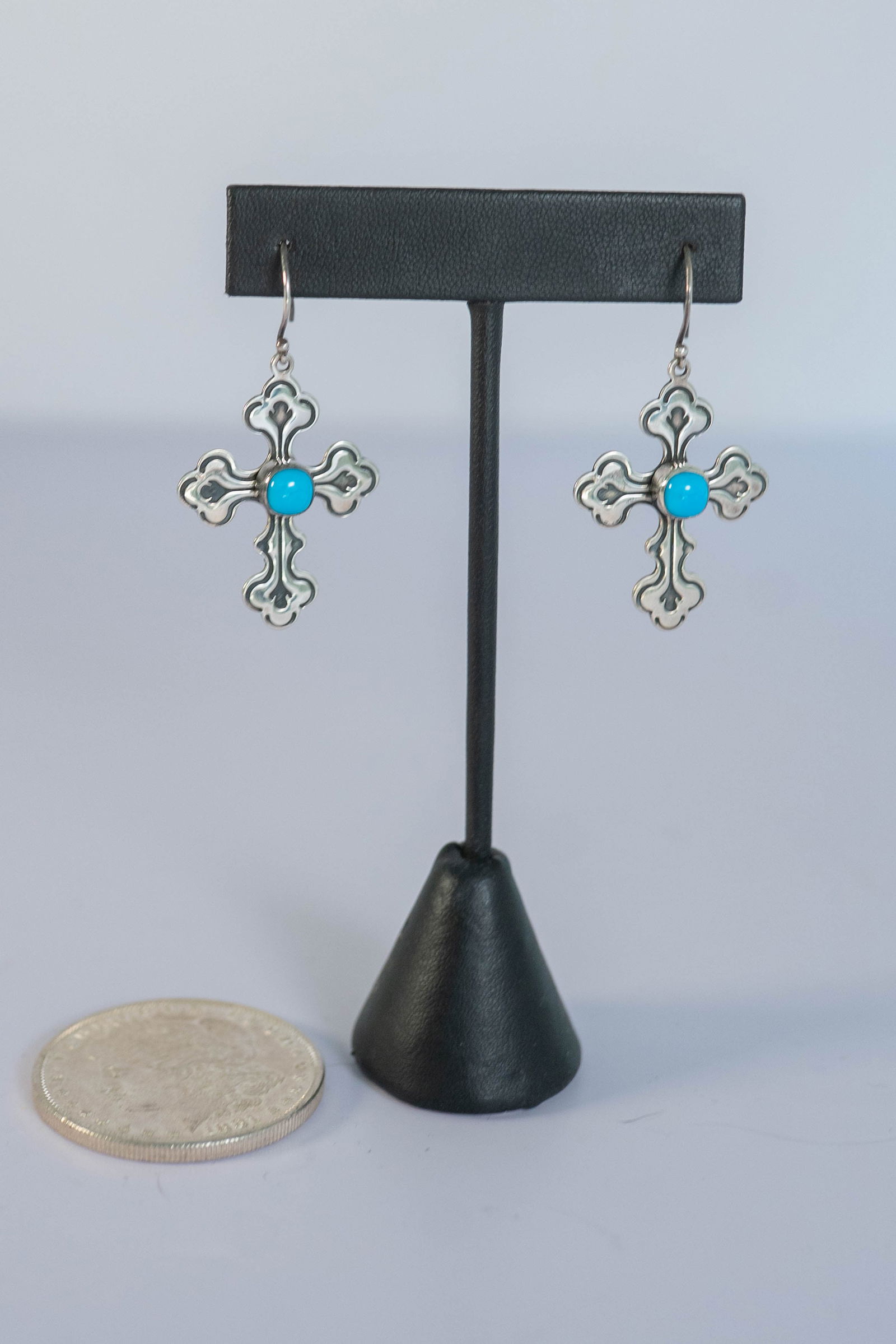 Navajo Hand Stamped Cross Earrings: Native American Navajo hand stamped sterling silver cross earrings featuring AAAAA Sleeping Beauty Turquoise round gemstone. L 1 7/8" from top of wire x 1" W. Signed RT.
